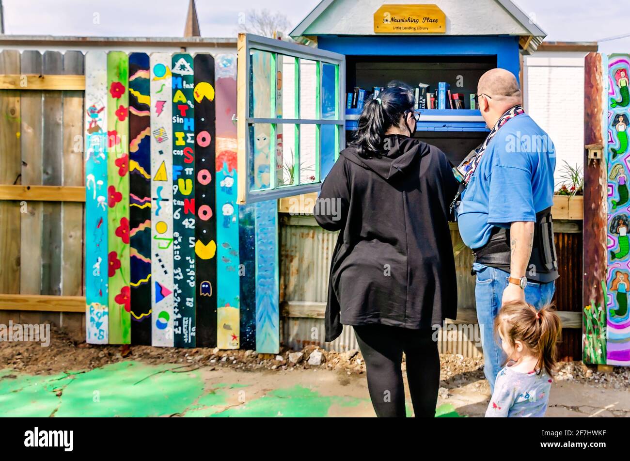 A family selects books from the Little Free Library at Ruth’s Roots, April 3, 2021, in Bay Saint Louis, Mississippi. Stock Photo