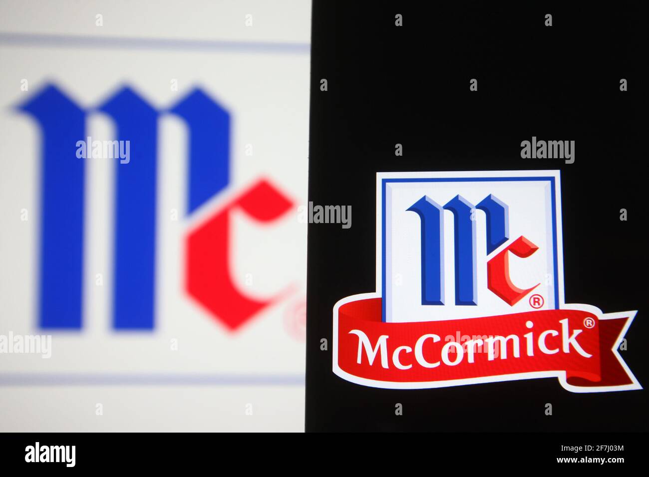 In this photo illustration the McCormick & Company logo is seen on a smartphone and a pc screen
