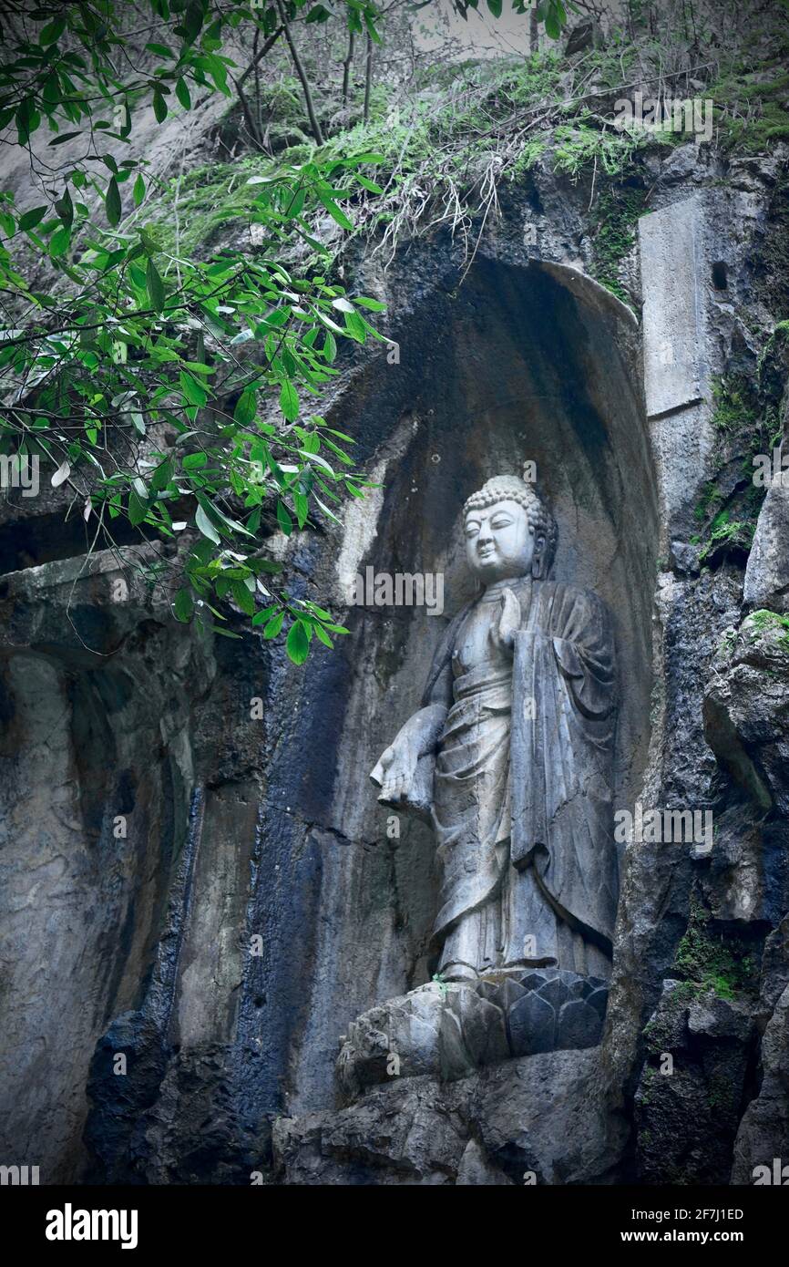A carved Buddha statue on a stone wall in Lingyin Temple locates in Hangzhou, Zhejiang, China. Stock Photo