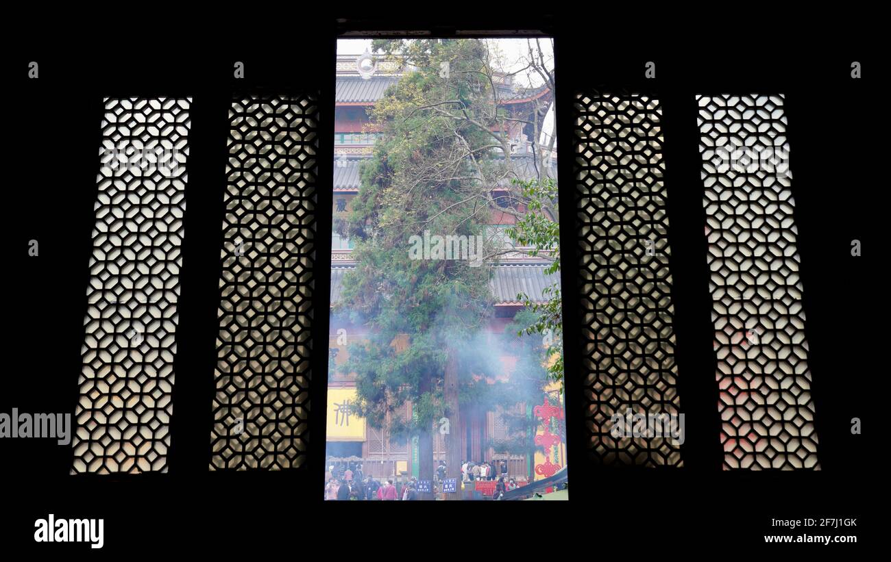 Huge old Chinese style door and window with smoke and trees outside in Lingyin Temple locates in Hangzhou, Zhejiang, China. Stock Photo