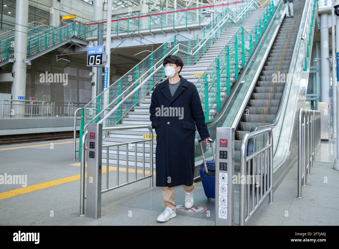 Asian man and woman with masks in escalator Stock Photo - Alamy
