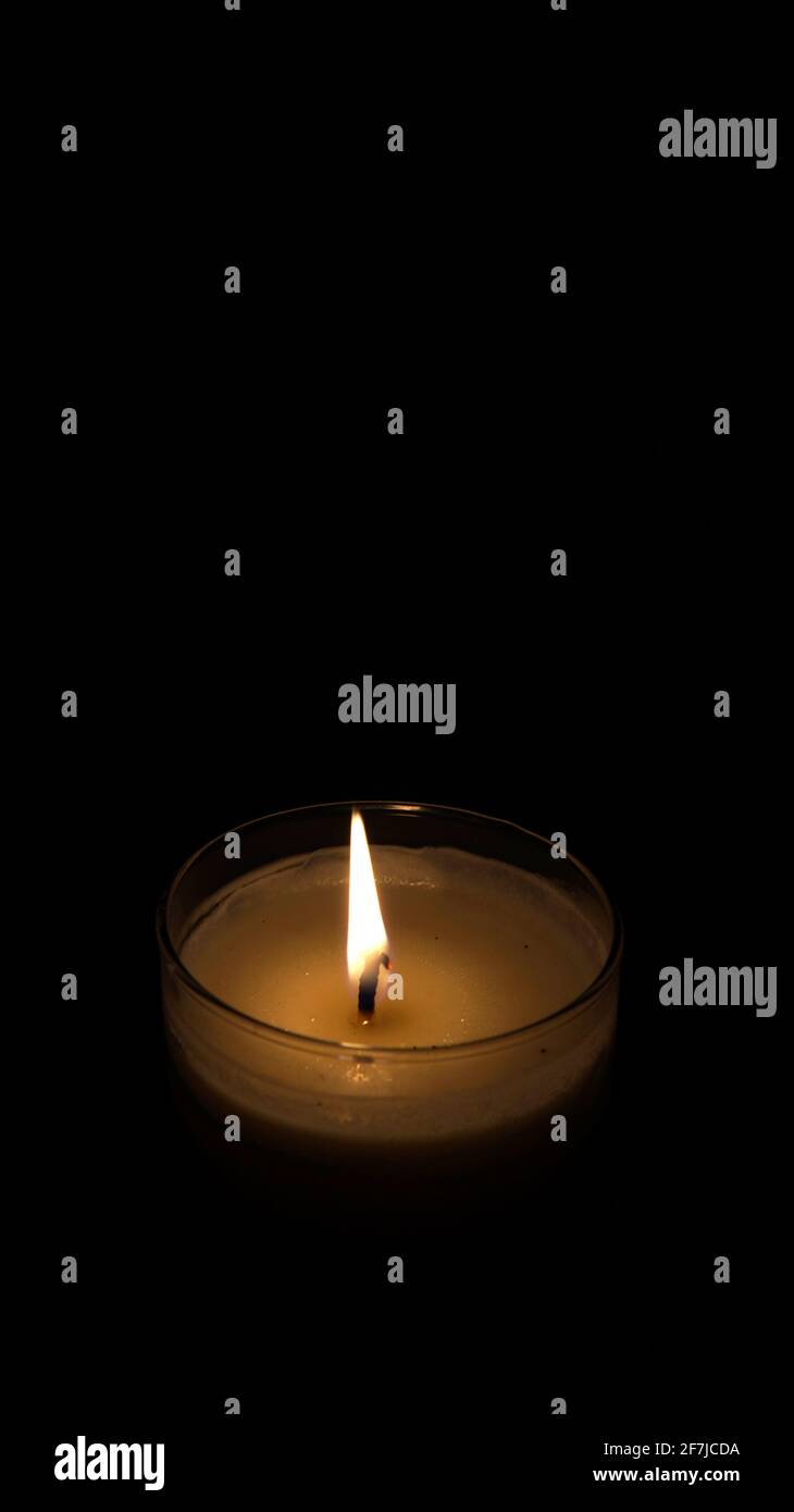 close view of lit candle over a black background Stock Photo
