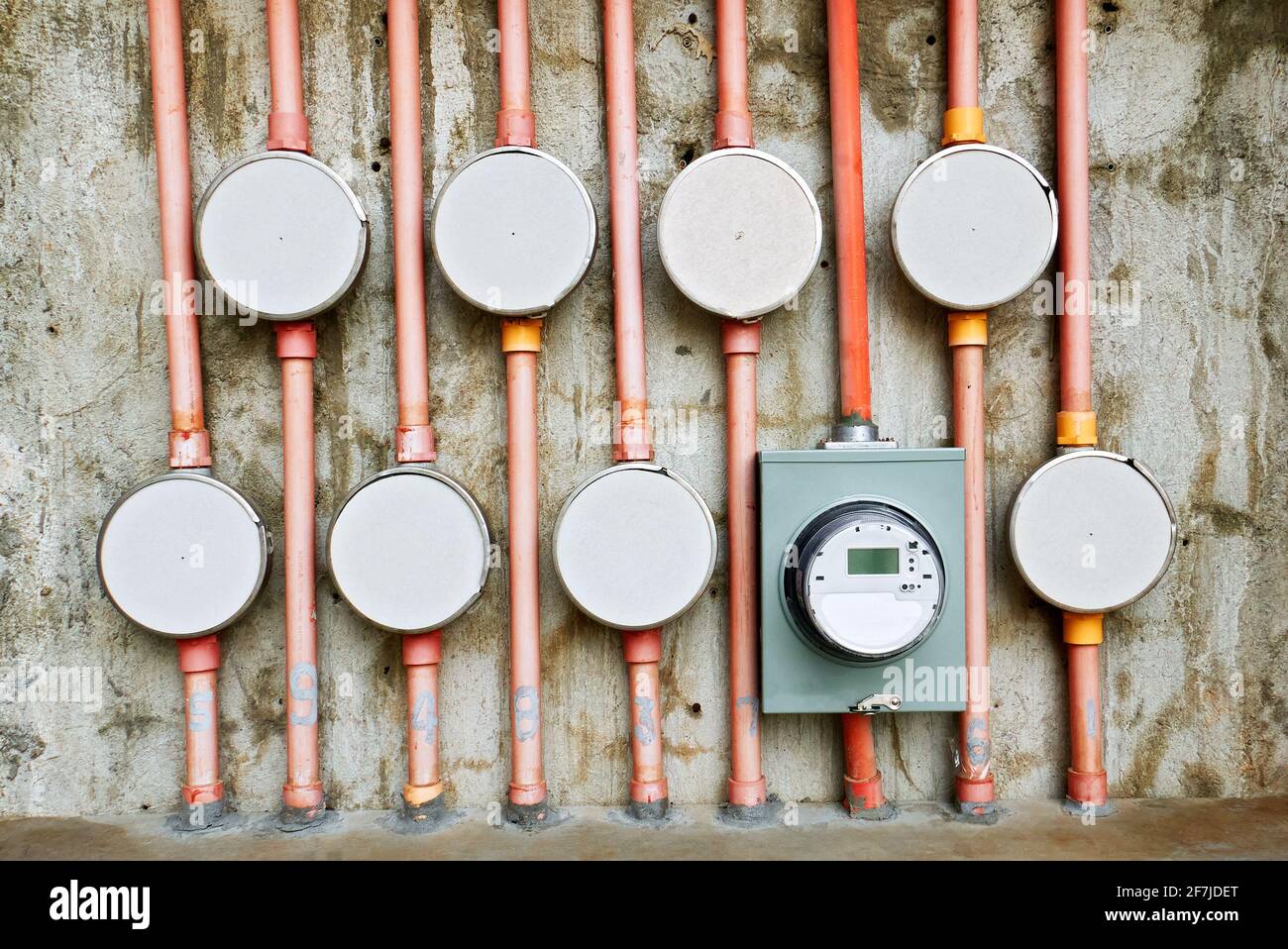 Close-up of a do-it-yourself installation set-up of electric meters and pvc pipes at a house wall, only one electric meter is attached Stock Photo