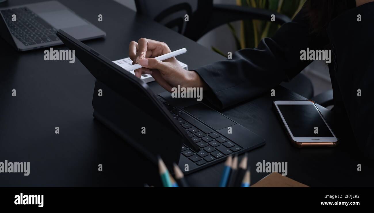 Creative designer designer carrying pencil and sketches her idea on laptop. Business day work lifestyle. Stock Photo