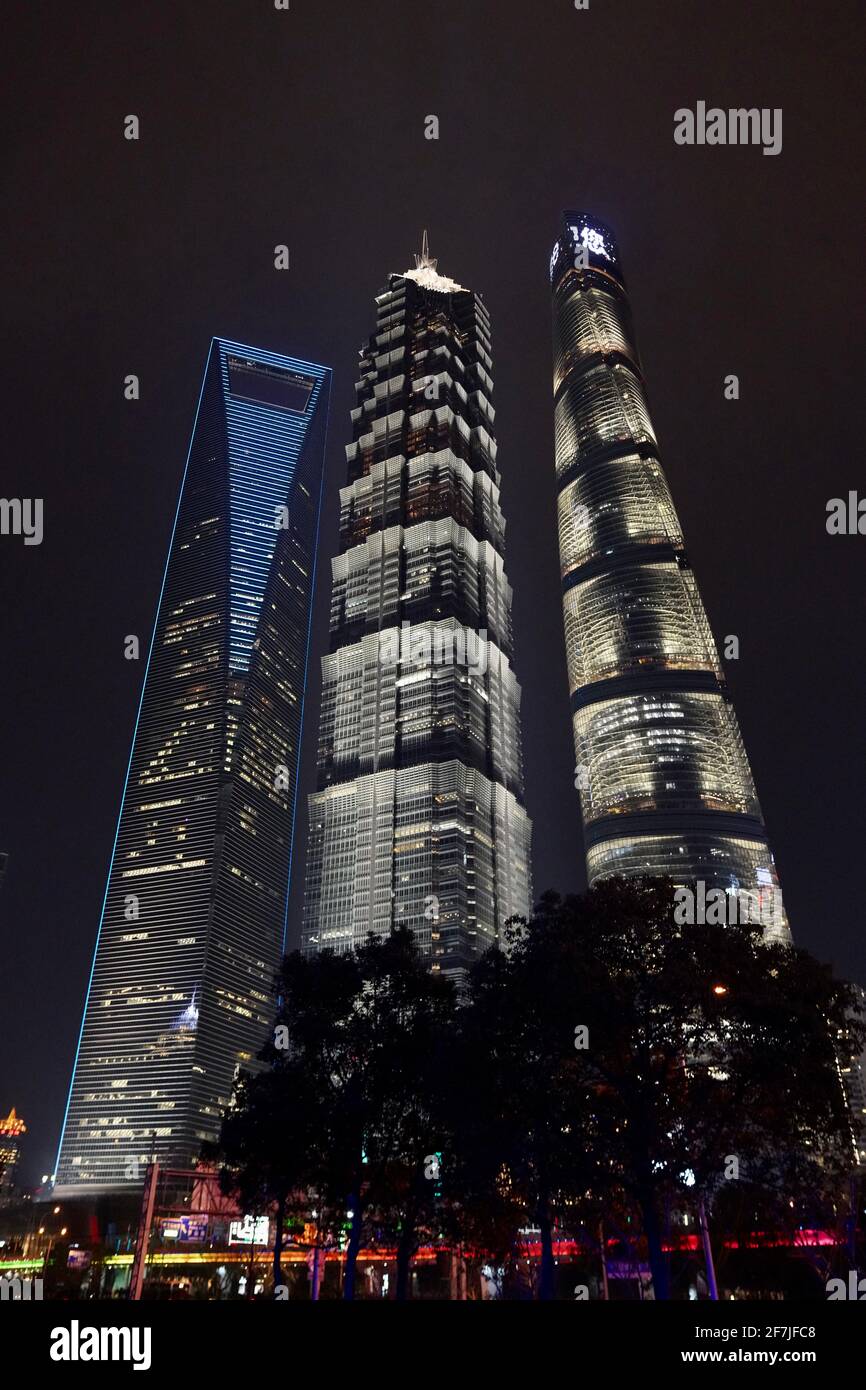 Three towers (Shanghai Tower, World Financial Center and Jinmao Tower) during night time with lights on. Stock Photo