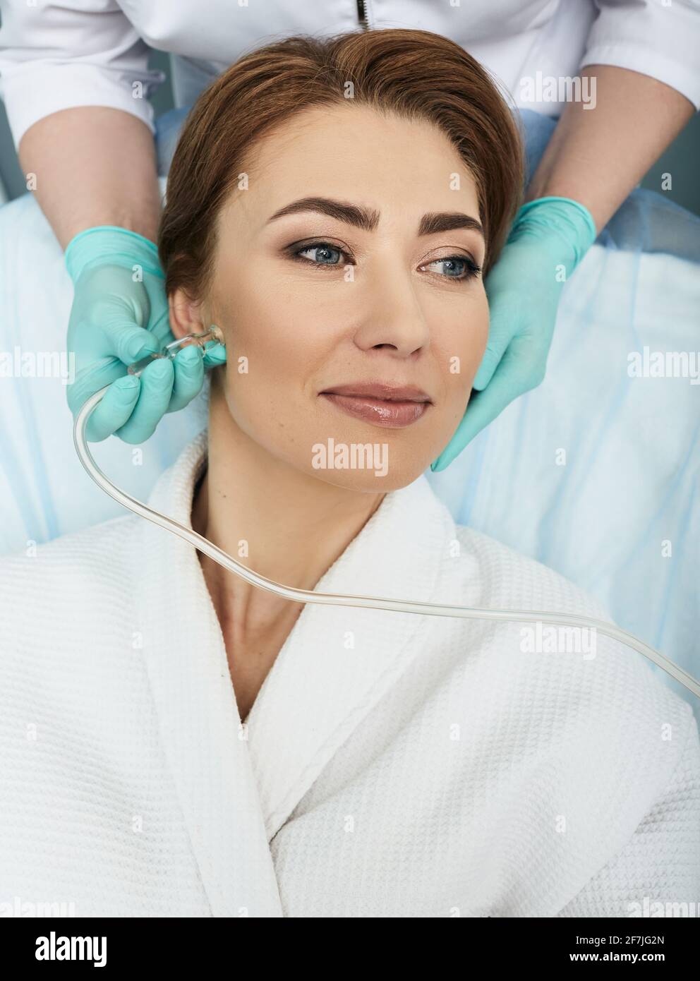 Close-up of a woman's face during ozone therapy procedure. Beautician treats female skin for rosacea, acne, post-acne using oxygen skin care machine Stock Photo