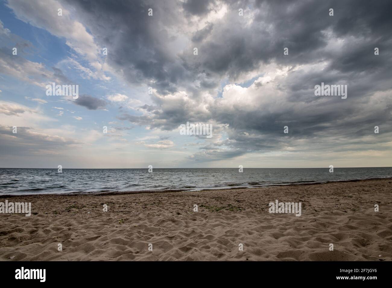 Light and shadows of evening beach in seashore. Colorful clouds. Stock Photo