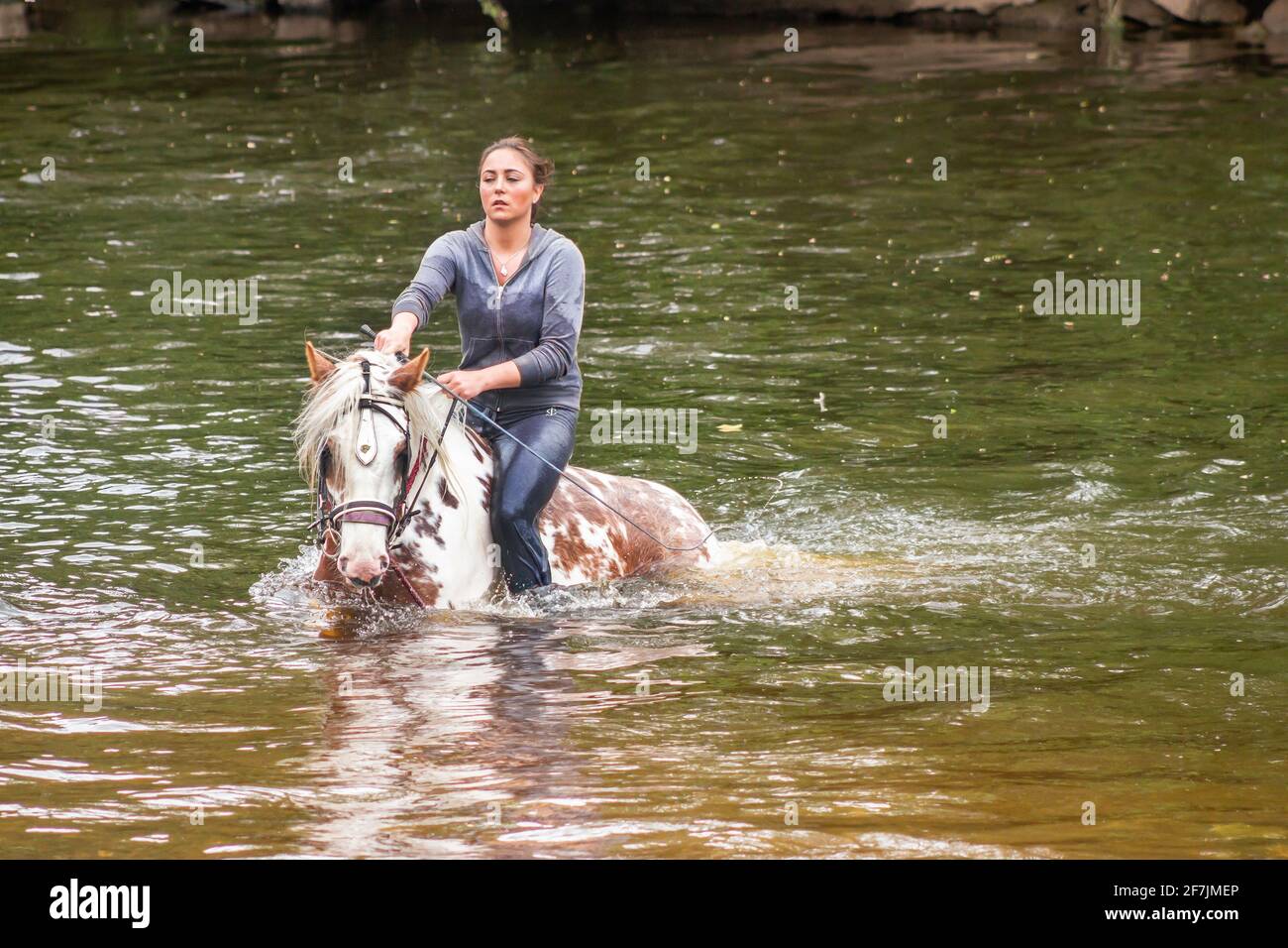 young-gypsy-traveller-woman-on-horse-in-river-in-appleby-horse-fair