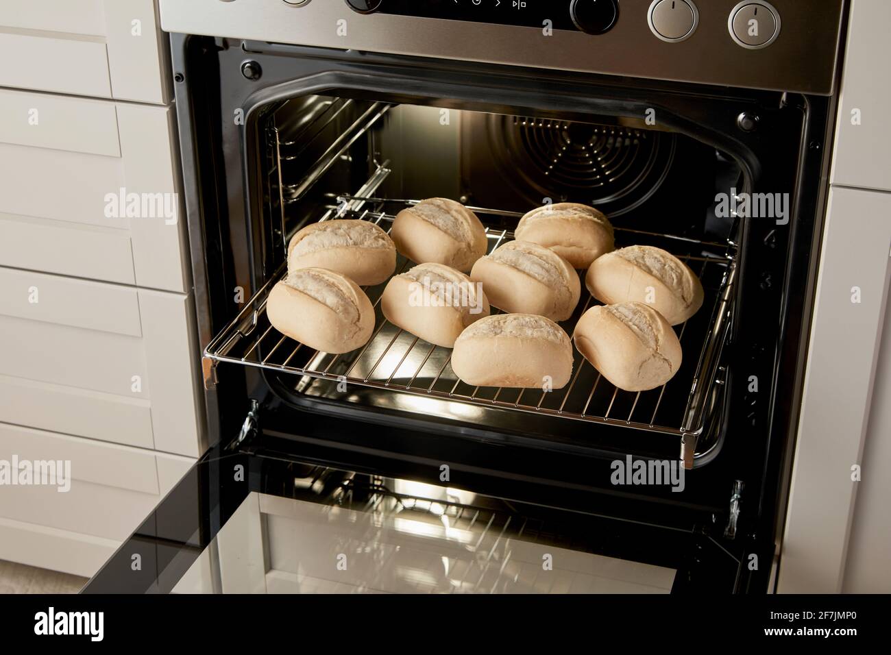 High angle of glide rack with delicious half baked bread roll buns in