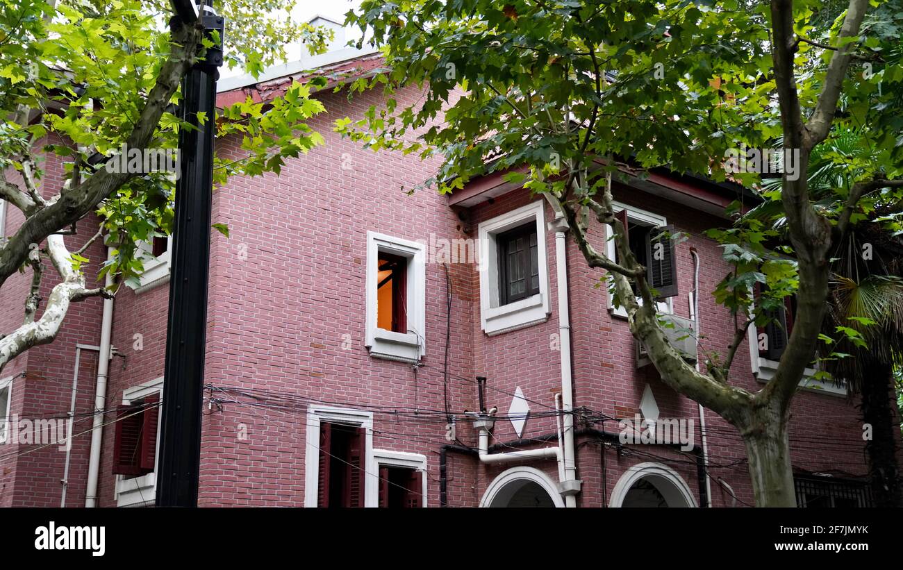 Green trees and old house with pnk wall in Wukang Road of Shanghai city. Stock Photo
