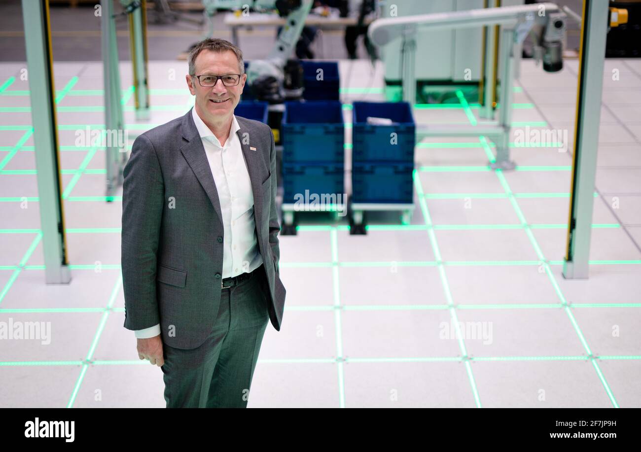 06 April 2021, Baden-Wuerttemberg, Stuttgart: Rolf Najork, member of the board of management of Robert Bosch GmbH, stands on an 'intelligent floor' from Bosch. The floor enables inductive energy transmission, for example - no more wiring is required. Photo: Christoph Schmidt/dpa Stock Photo