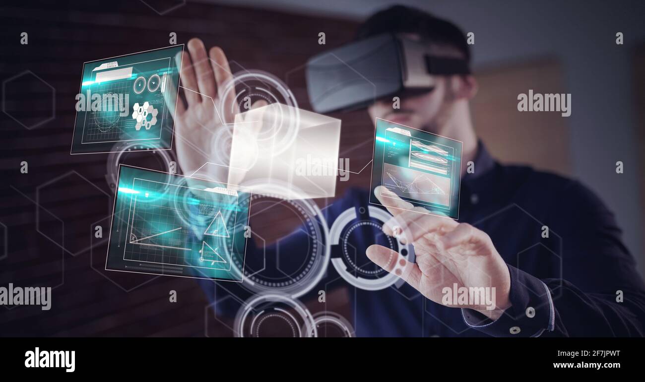 Composition of caucasian man using vr headset touching shapes and data background Stock Photo
