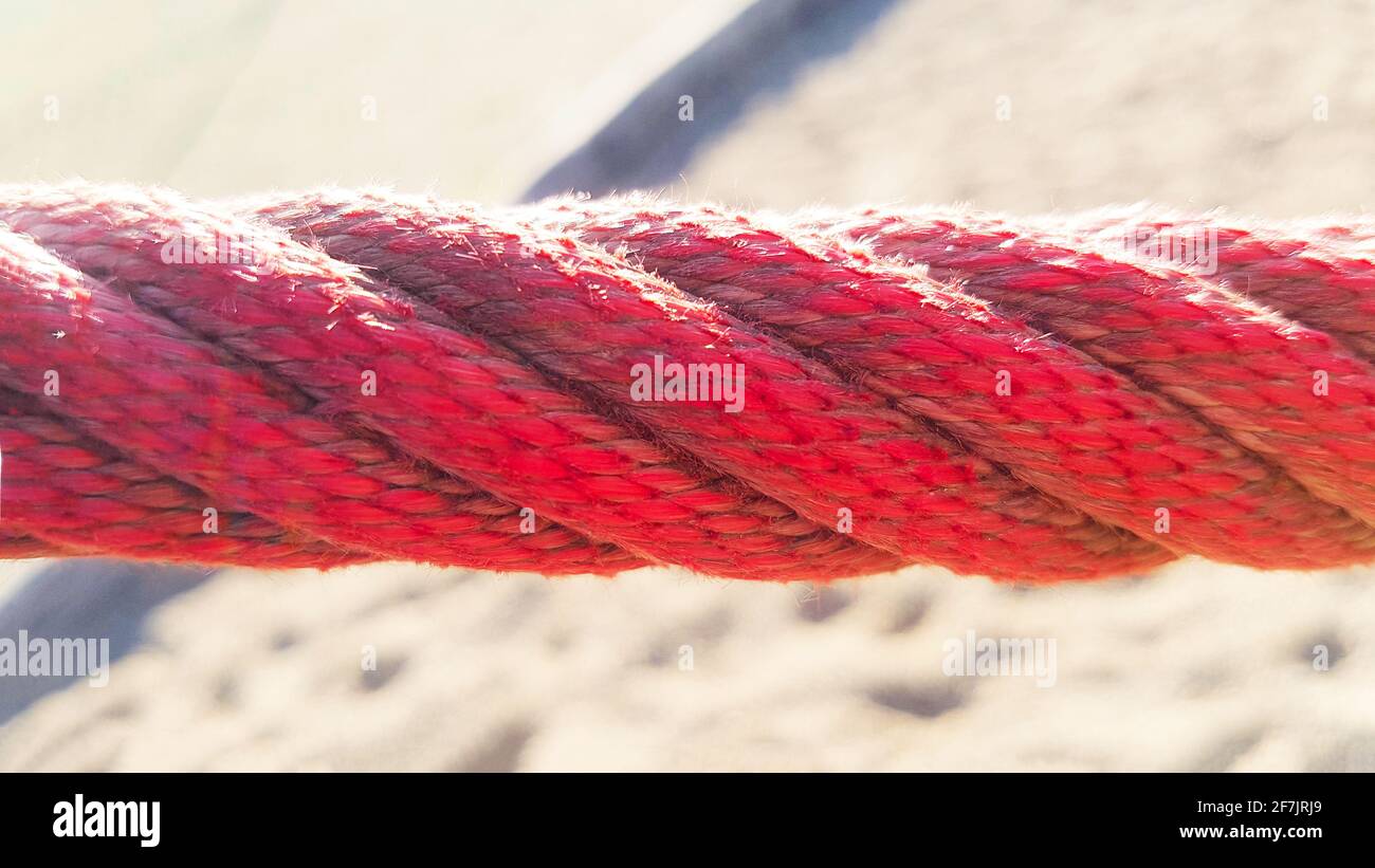 Red rope border maritime barrier VIP beach hanging path playground sandpit summer sun shining fastening braided twisted twisted hold chain children Stock Photo