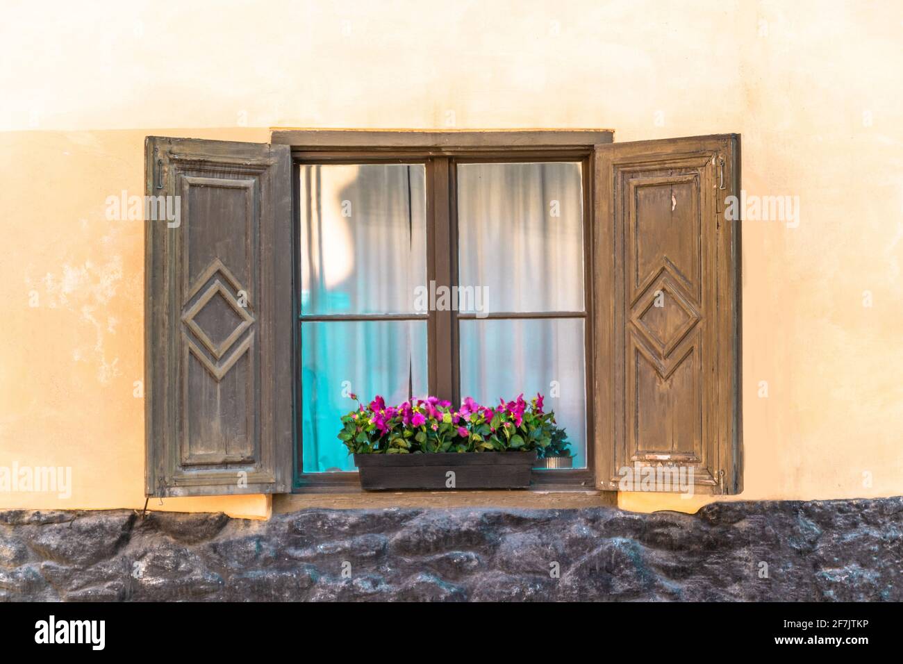 Bavarian or austrian wooden window with red geranium flowers on house ...