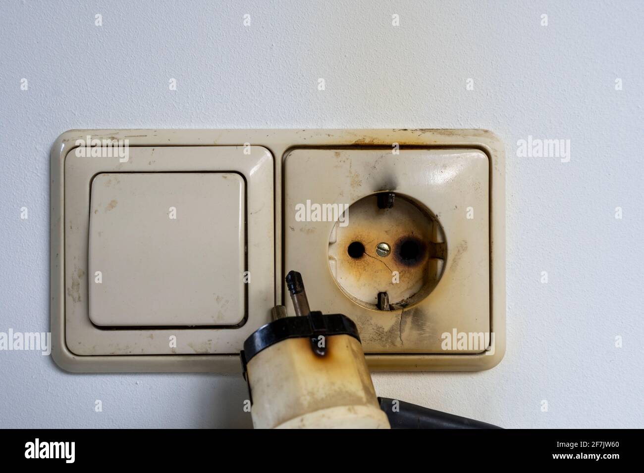 Close-up of electrical fire with the wire and wall plug Stock Photo