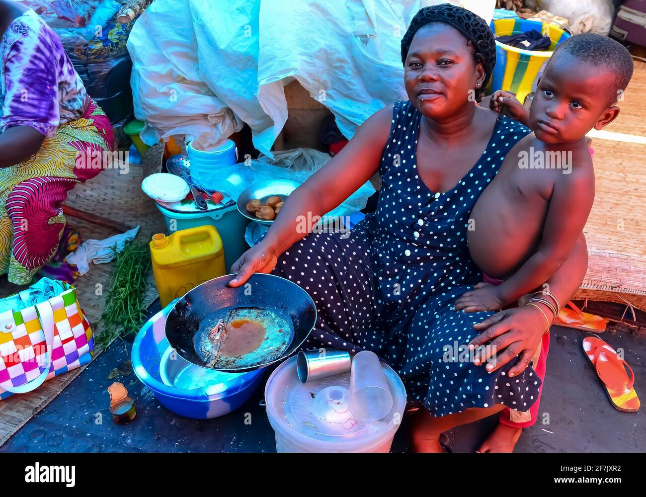 Lunch time, so mama cooks fufu for lunch. Two of the 800+ passengers on a barge travelling from Kisangani to Kinshasa, Democratic Republic of Congo. Stock Photo