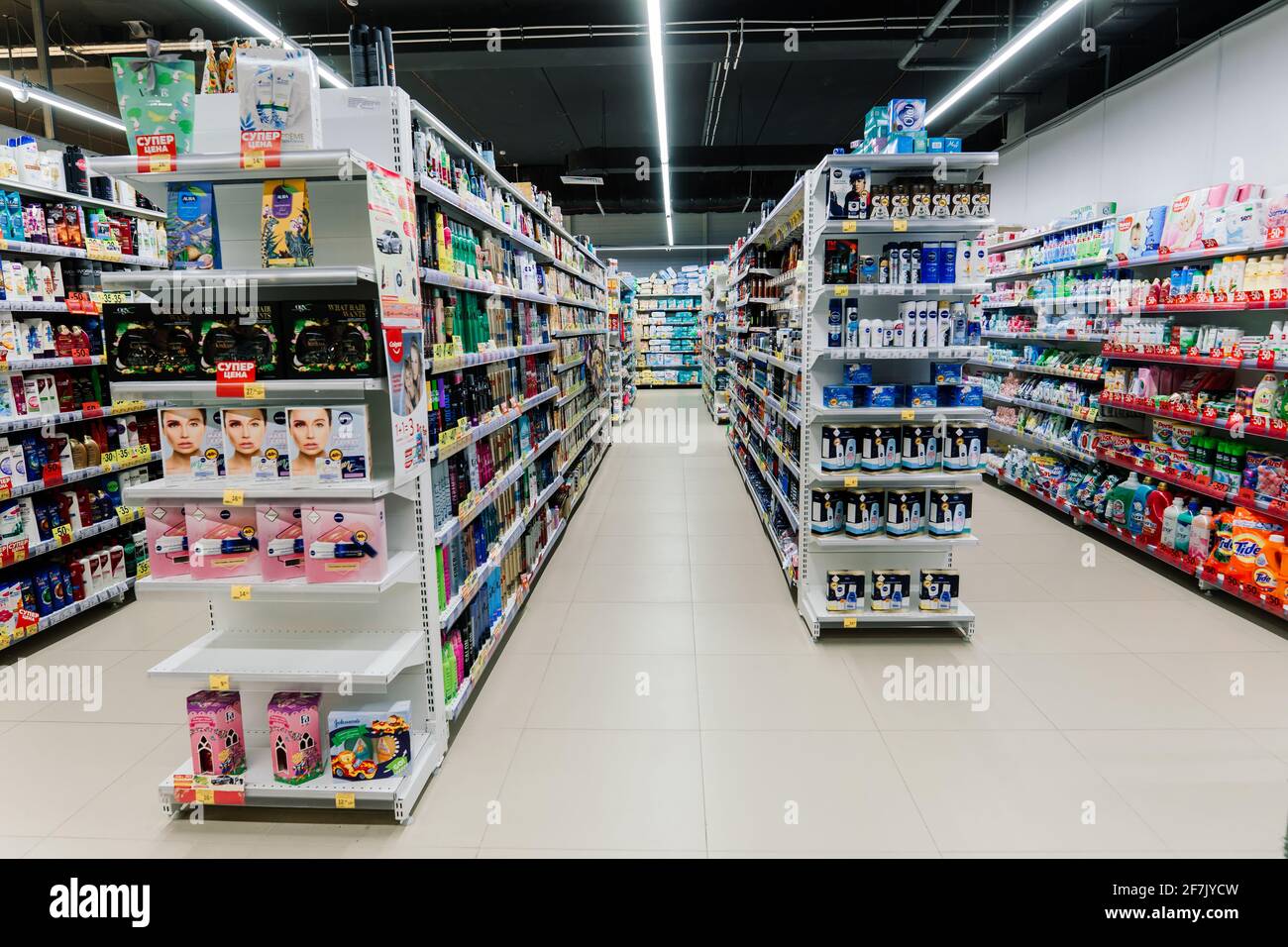 An assortment of washing powders of different brands on shelves in the