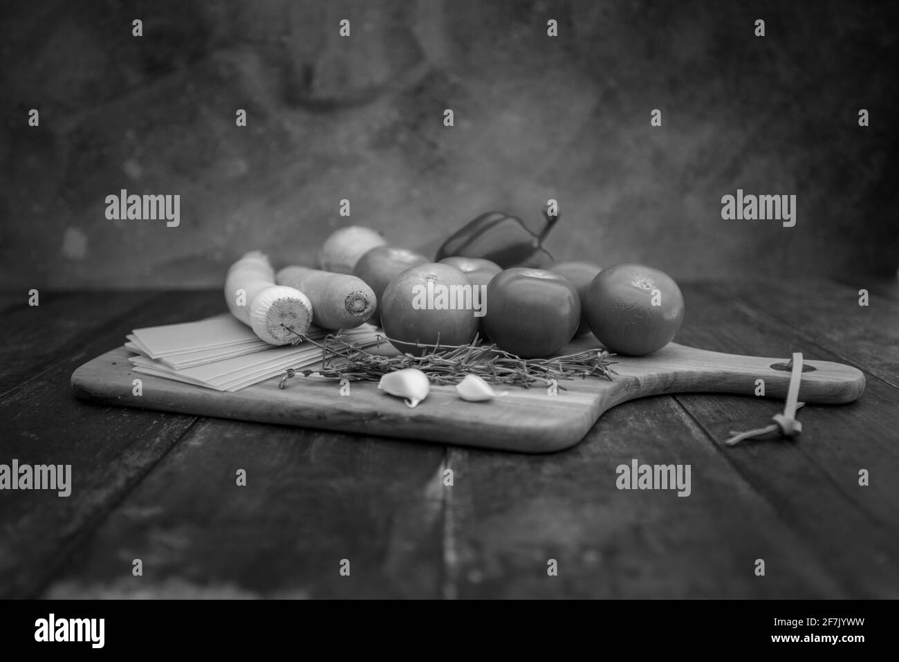 Different ingredients for cooking Italian lasagna on a wooden background. Black and white High quality photo Stock Photo