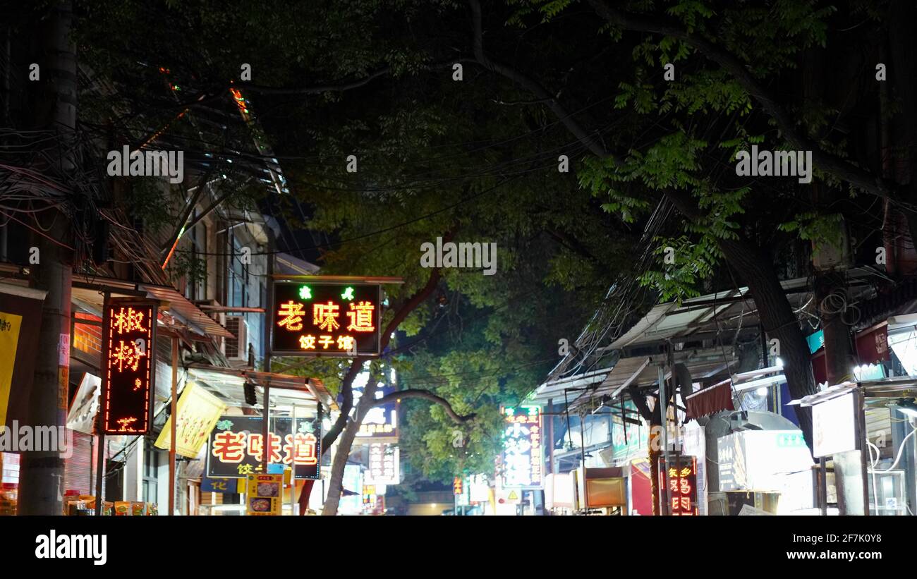 The famous night market in Xi'an with lots of small shops and billboard lighted on. Stock Photo