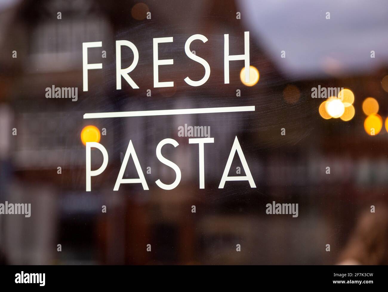 Fresh pasta sign in glass window of Italian restaurant blurred background some reflection, UK Stock Photo