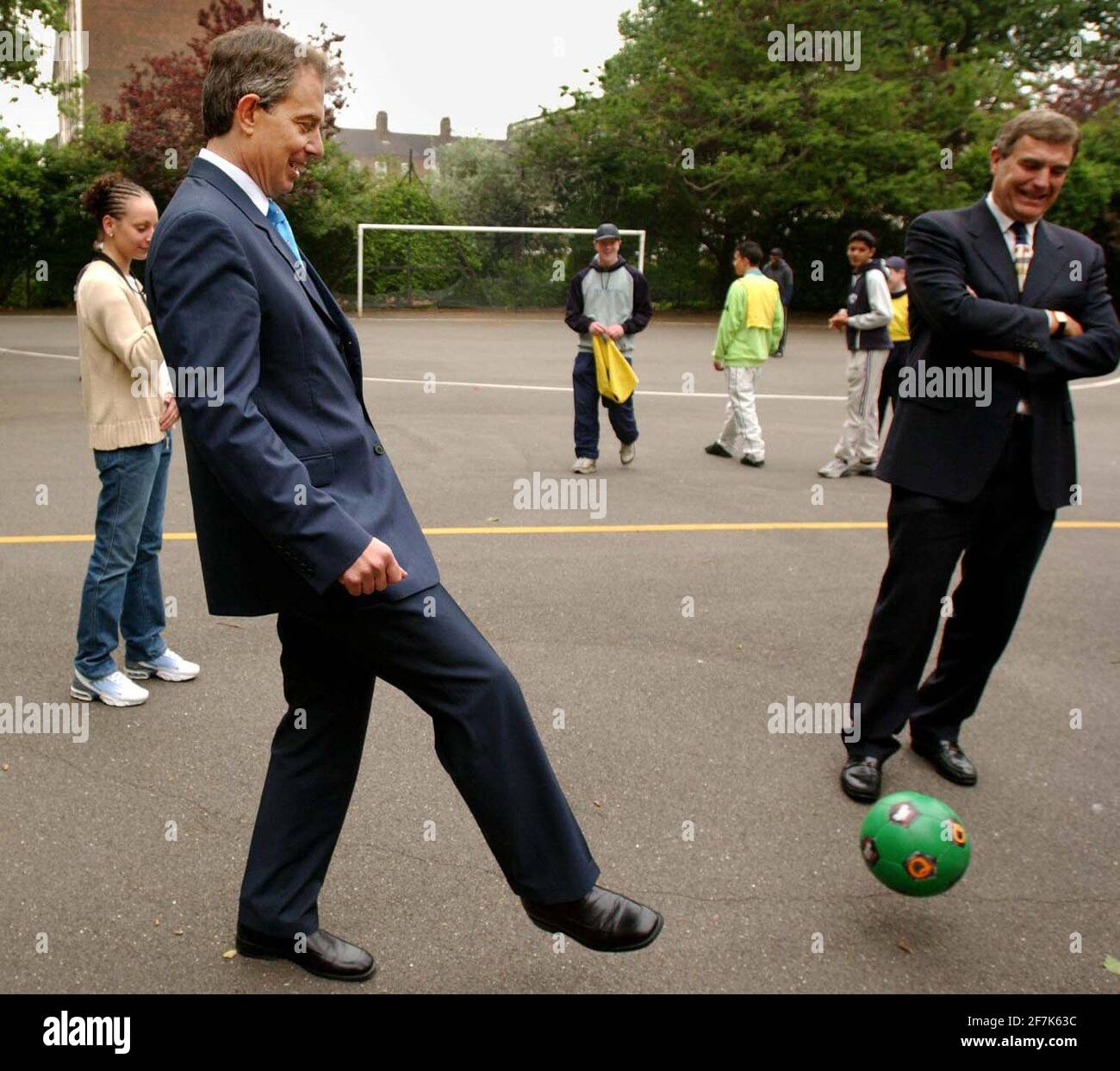 Britain's Prime Minister Tony Blair (centre) and former West Ham and England star Trevor Brooking play football with local children at Newington Gardens in London, Thursday 9, 2002.  Mr Blair was launching a new governmental programme to try and steer young people away from street crime Stock Photo