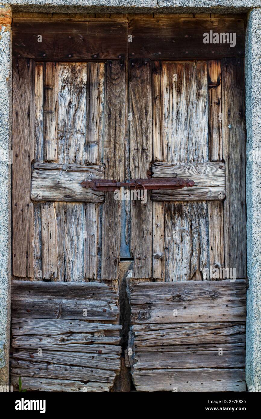 Old wooden door in Italy with iron sliding lock detail. Copy space. Stock Photo