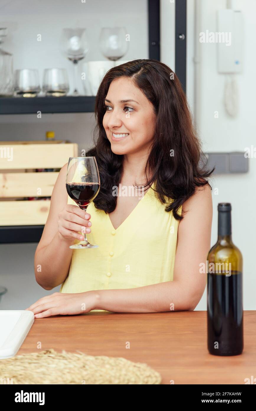 young woman drinking wine in the kitchen at home Stock Photo