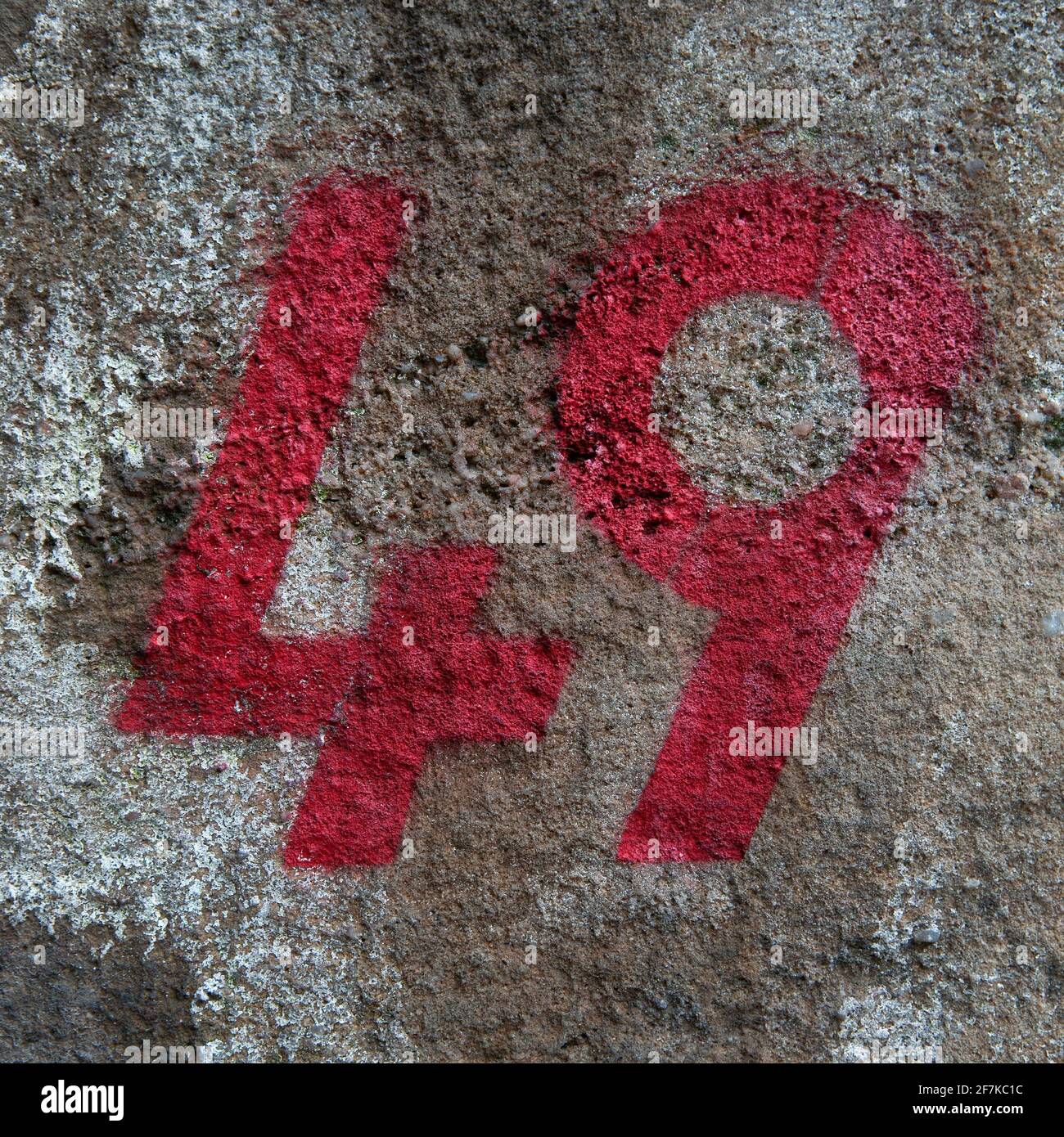A Close Up Of The Number 49 Stencilled In Red Paint On A Distressed Exterior Wall In London, UK Stock Photo
