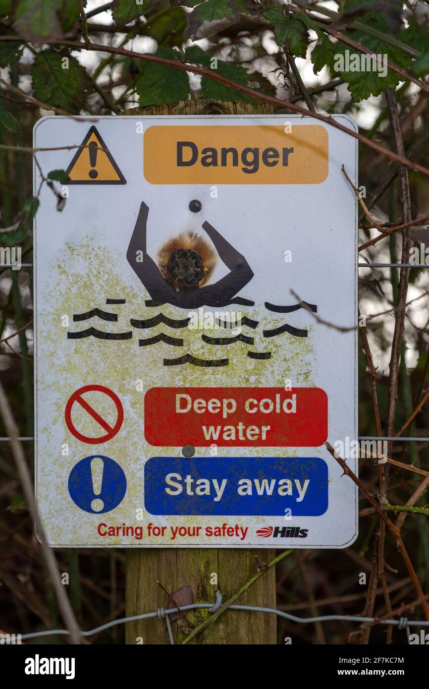 Sign warning of danger of deep cold water Hills waste management, Calne, Wiltshire, England, UK Stock Photo
