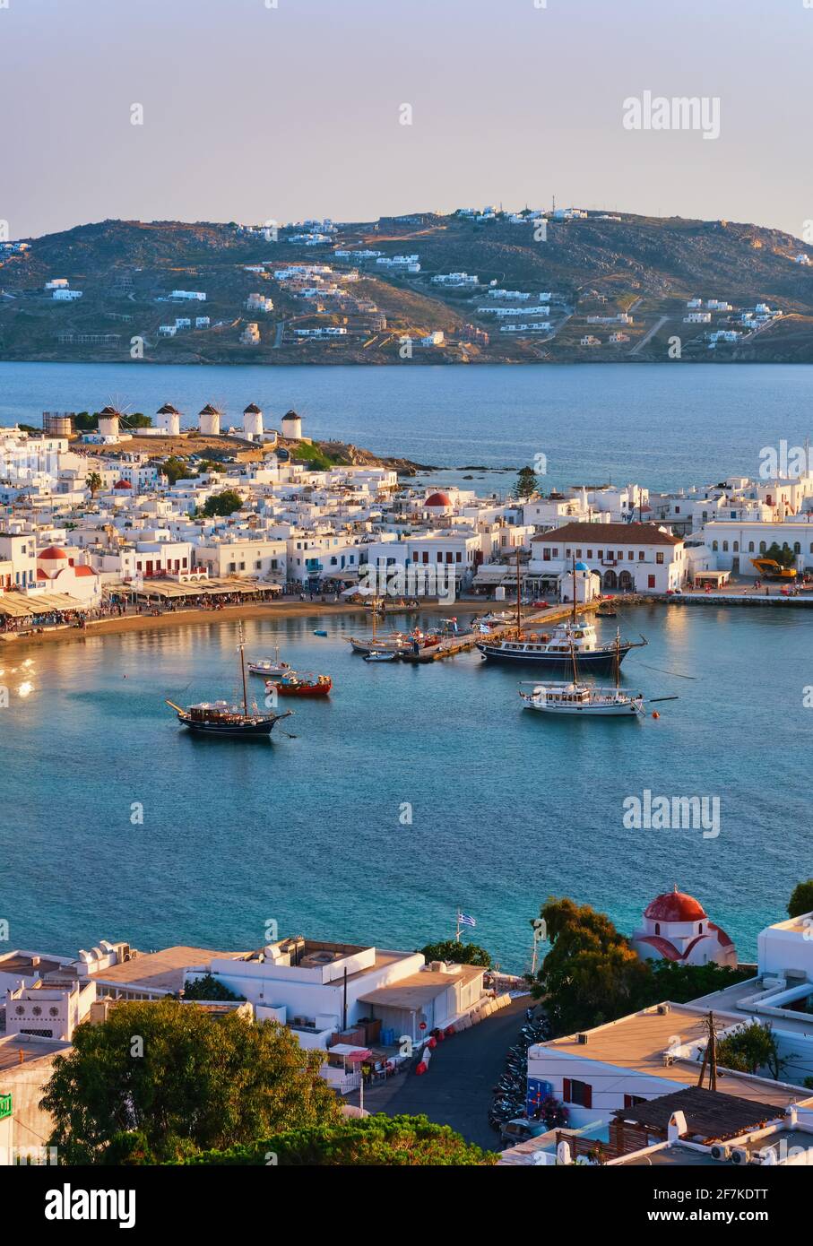 Beautiful sunset view of Mykonos, Cyclades, Greece, its port, windmills. Cruises, ship, whitewashed houses. Vacation, leisure, Mediterranean lifestyle Stock Photo