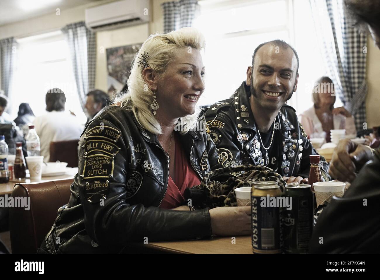 Rocker couple wearing leather jackets patches and badges drinking beer in Jacks Hill Cafe, Northamptonshire, England. Stock Photo