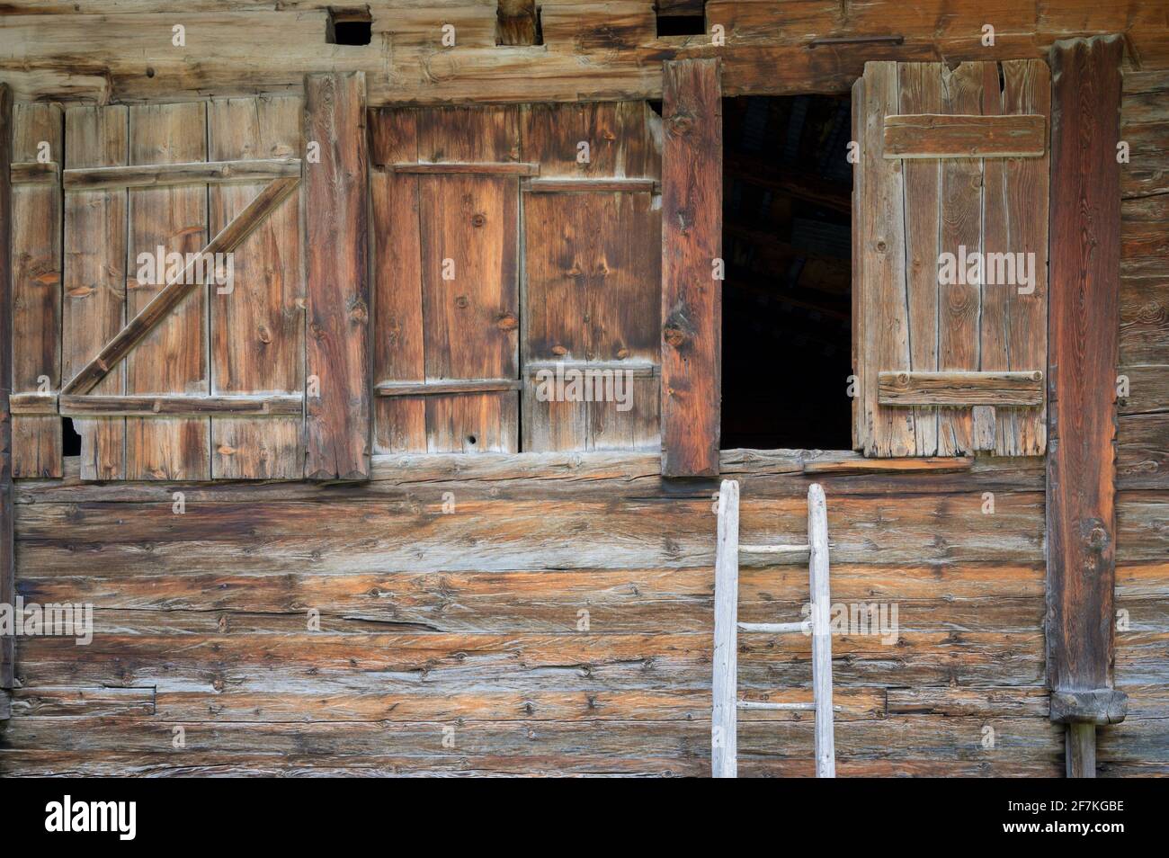 Rustic wooden window shutters with wooden ladder at an alpine barn, Oberwald, Switzerland Stock Photo