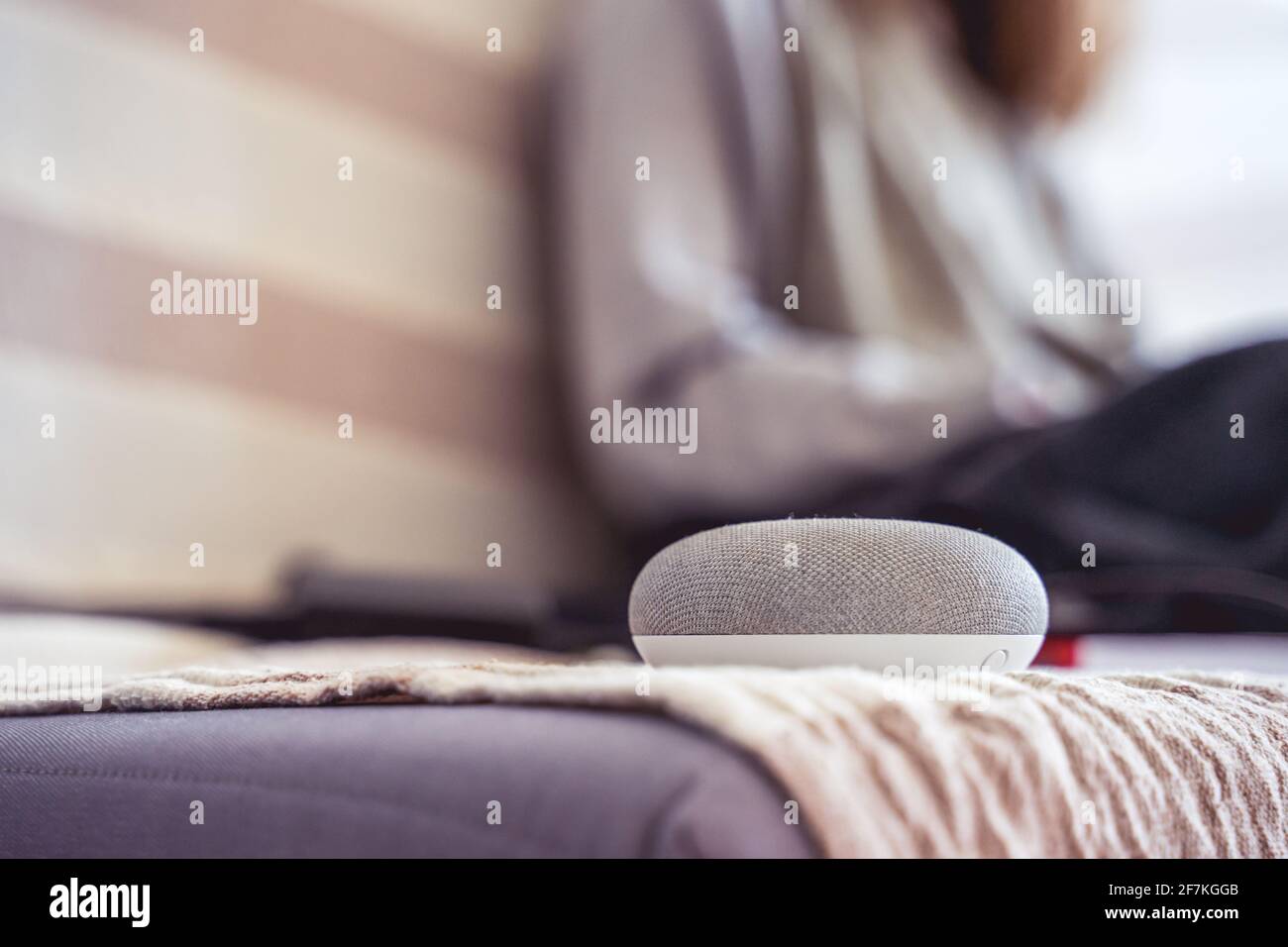 voice controlled smart speaker in a interior. female working in background Stock Photo