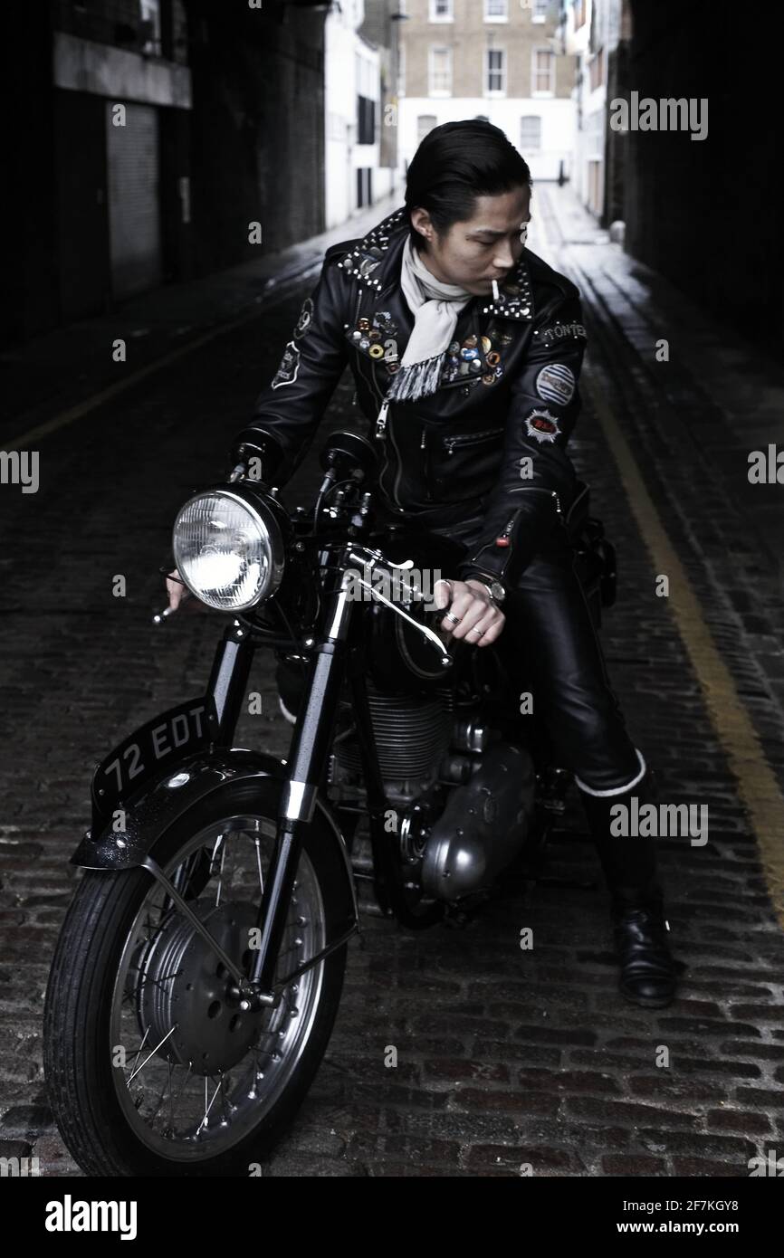 Rocker sitting on Triumph cafe race motorcycle in London , England ...