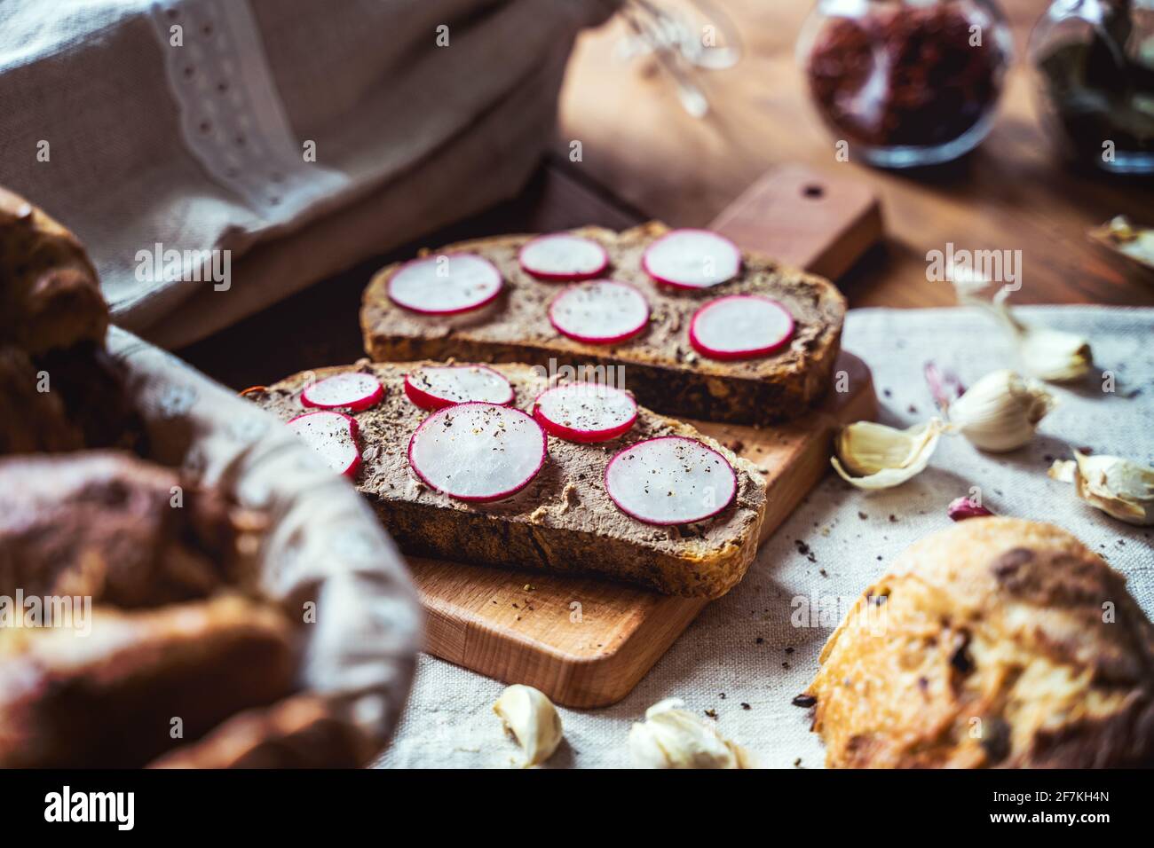 Sliced and plated Sourdough bread. Vegan vegetables on rustic crusty fresh country bread. Stock Photo