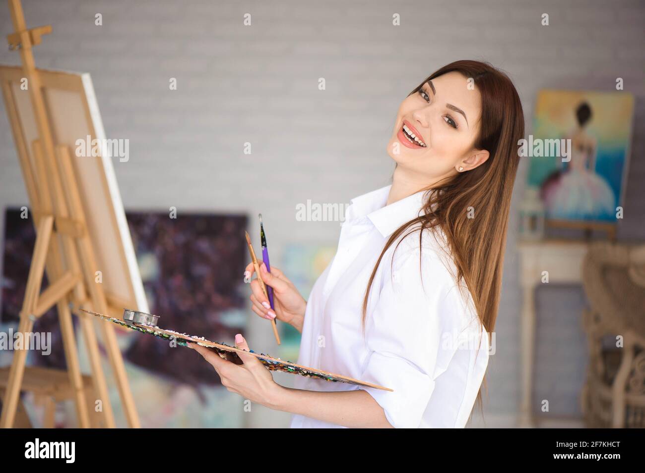 Young female artist painting picture in studio Stock Photo - Alamy