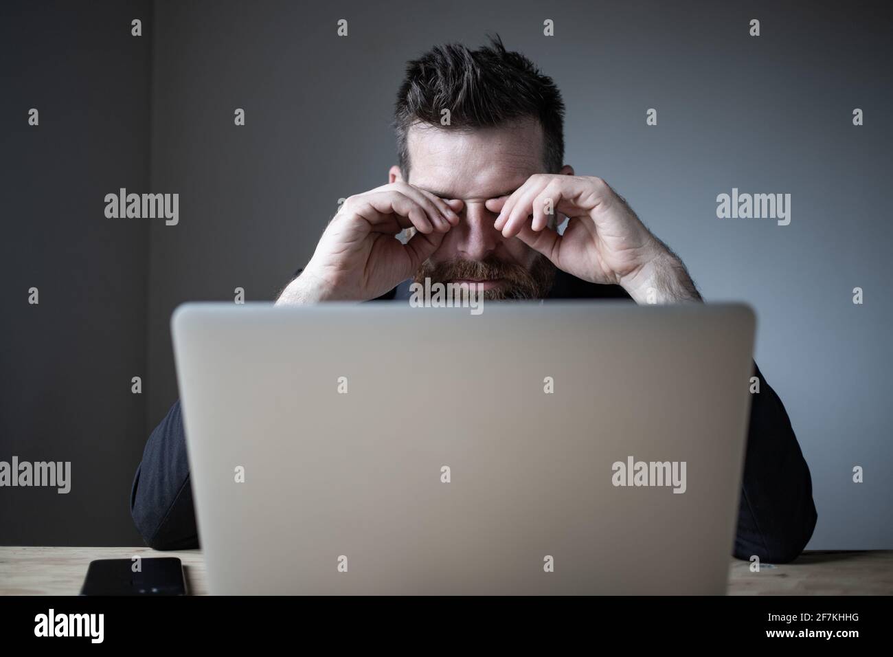 tired businessman touching his eyes bad eyesight, exhaustion Stock