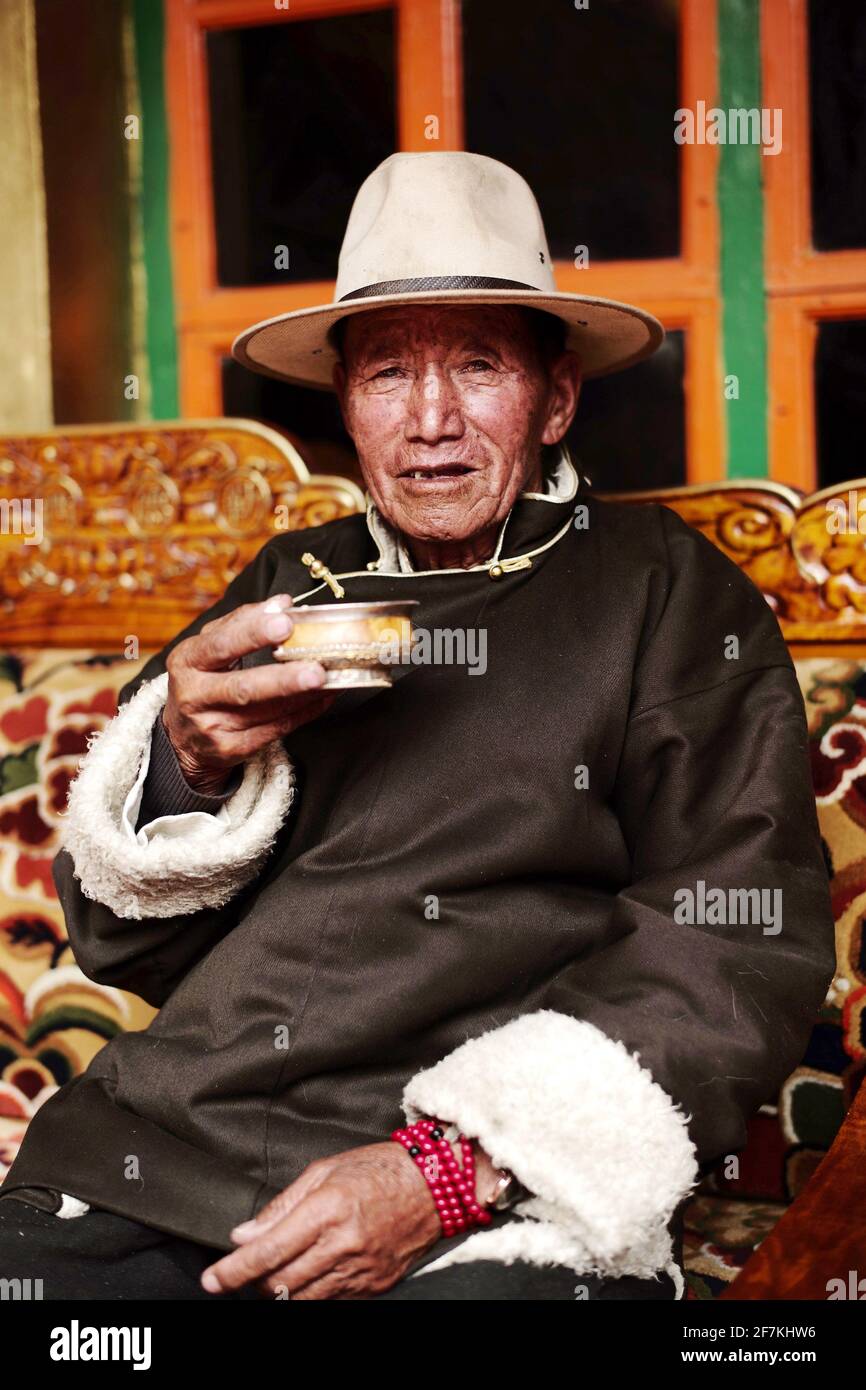 (210408) -- LHASA, April 8, 2021 (Xinhua) -- Dro Dra has a cup of buttered tea at home in Xigaze of southwest China's Tibet Autonomous Region, March 20, 2021. Dro Dra, an 85-year-old villager in Xigaze, was once a serf in old Tibet. Back to the old time, despite the hard work all year round, Dro Dra's family could not have a grain of highland barley they grew for themselves. Year after year, they struggled in a vicious circle of borrowing food, paying taxes to the lord and returning food. 'Boiling water requires firewood, but every grass and tree in the manor belongs to the lord. If we wer Stock Photo
