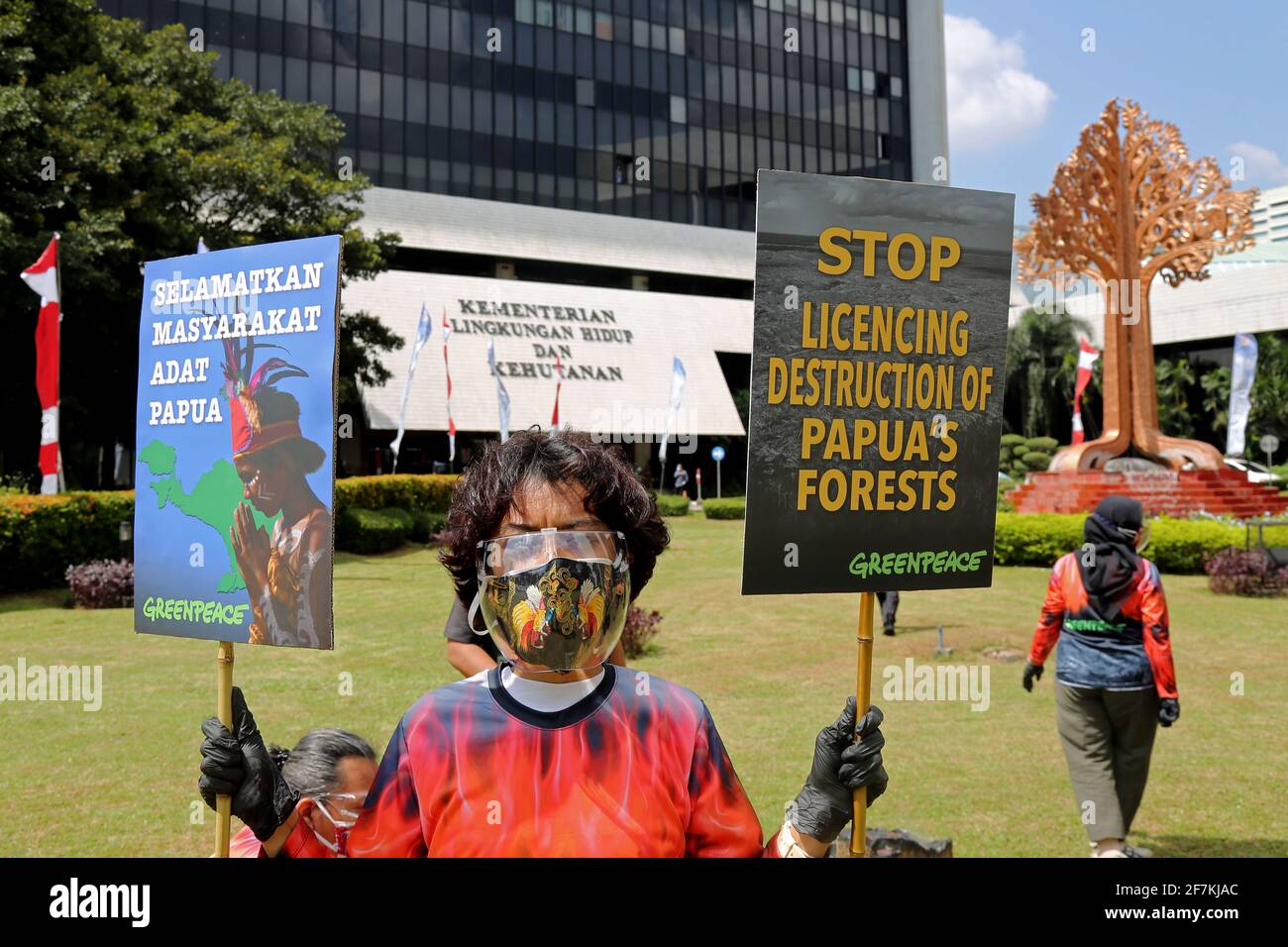 An environmental activist holds placards expressing her opinion during the demonstration.Greenpeace staged an action in front of the Ministry of Environment's building to stop violations of issuing forest release permits in Papua. The purpose of this action is to demand that the Government take corrective actions that forests and plantations that have not been damaged can be returned to the Indigenous Papuan people. Stock Photo