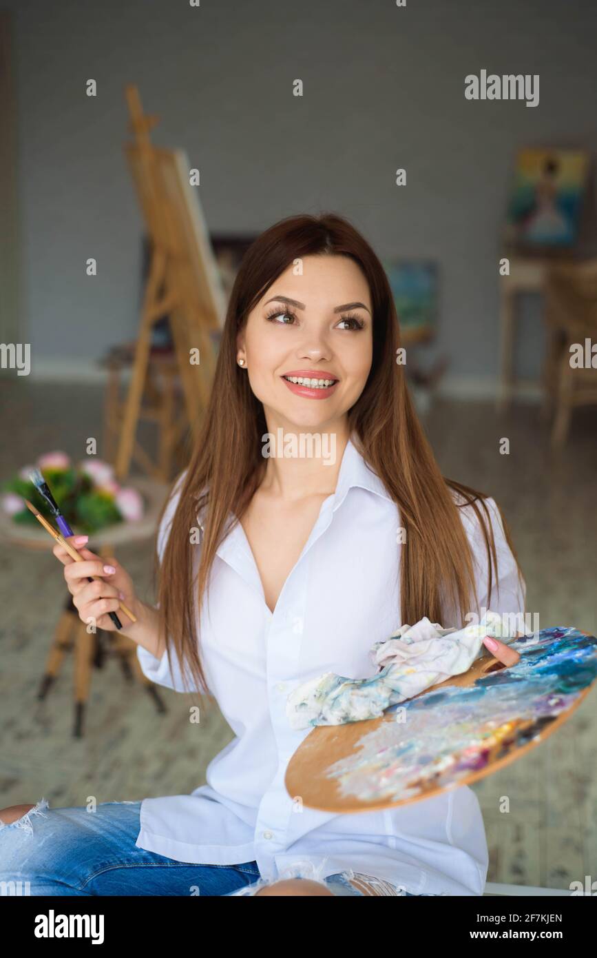 Portrait Of Talented Young Woman Painting Picture In Art Studio With