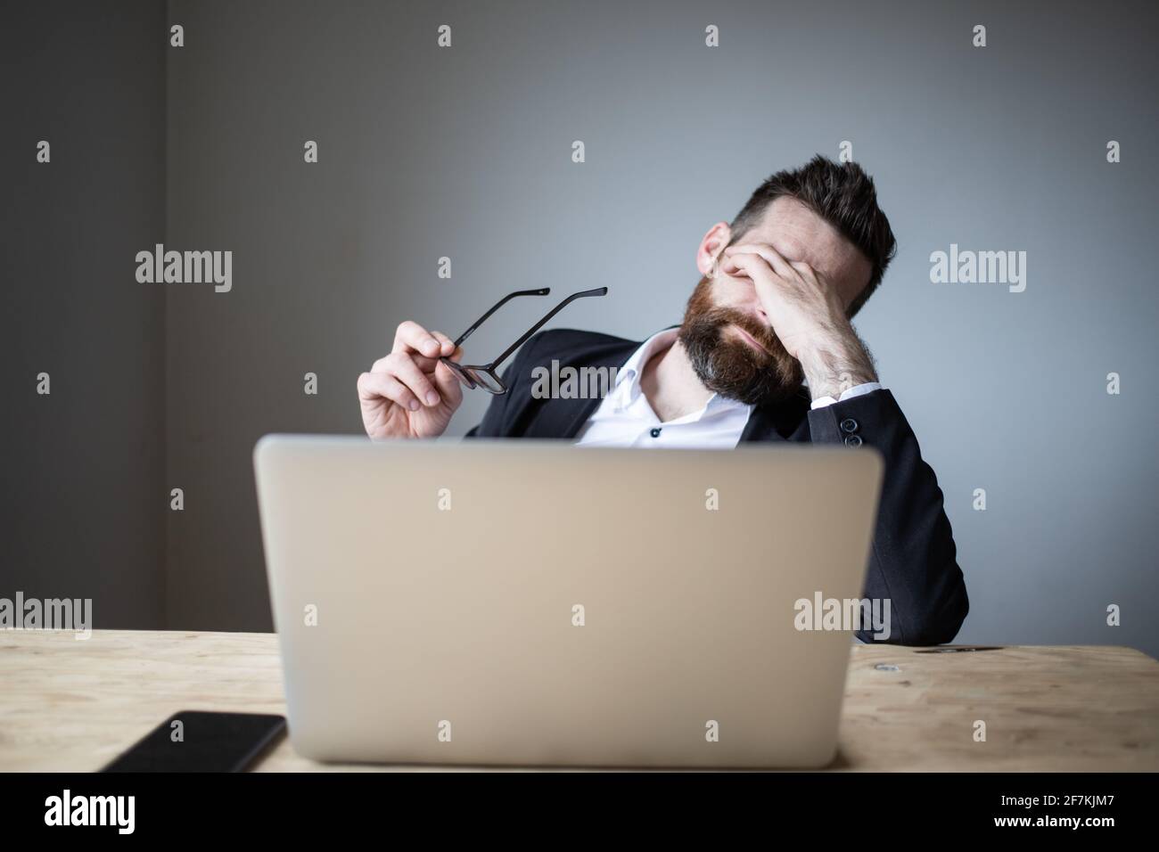 tired businessman touching his eyes bad eyesight, exhaustion Stock