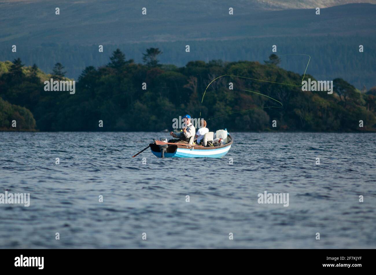 Ireland fly fishing. Adult man and young boy fishing from a boat in the Killarney Lakes in Killarney National Park, County Kerry, Ireland Stock Photo