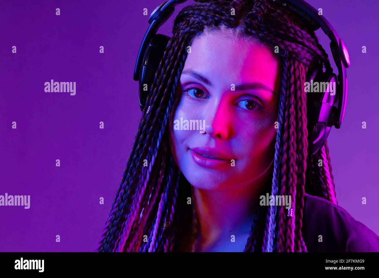 Beautiful woman with long hair in braids listening to music with ...