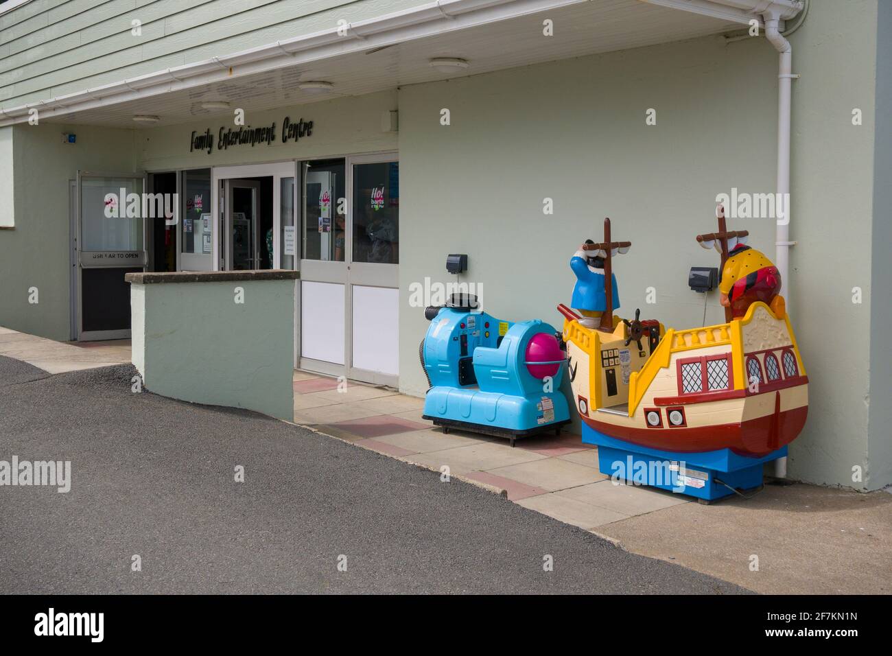 Children’s coin operated amusement rides (Teletubbies Noo Noo and Captain Pugwash) outside a family entertainment centre in the seaside village of Westward Ho!, North Devon, England. Stock Photo