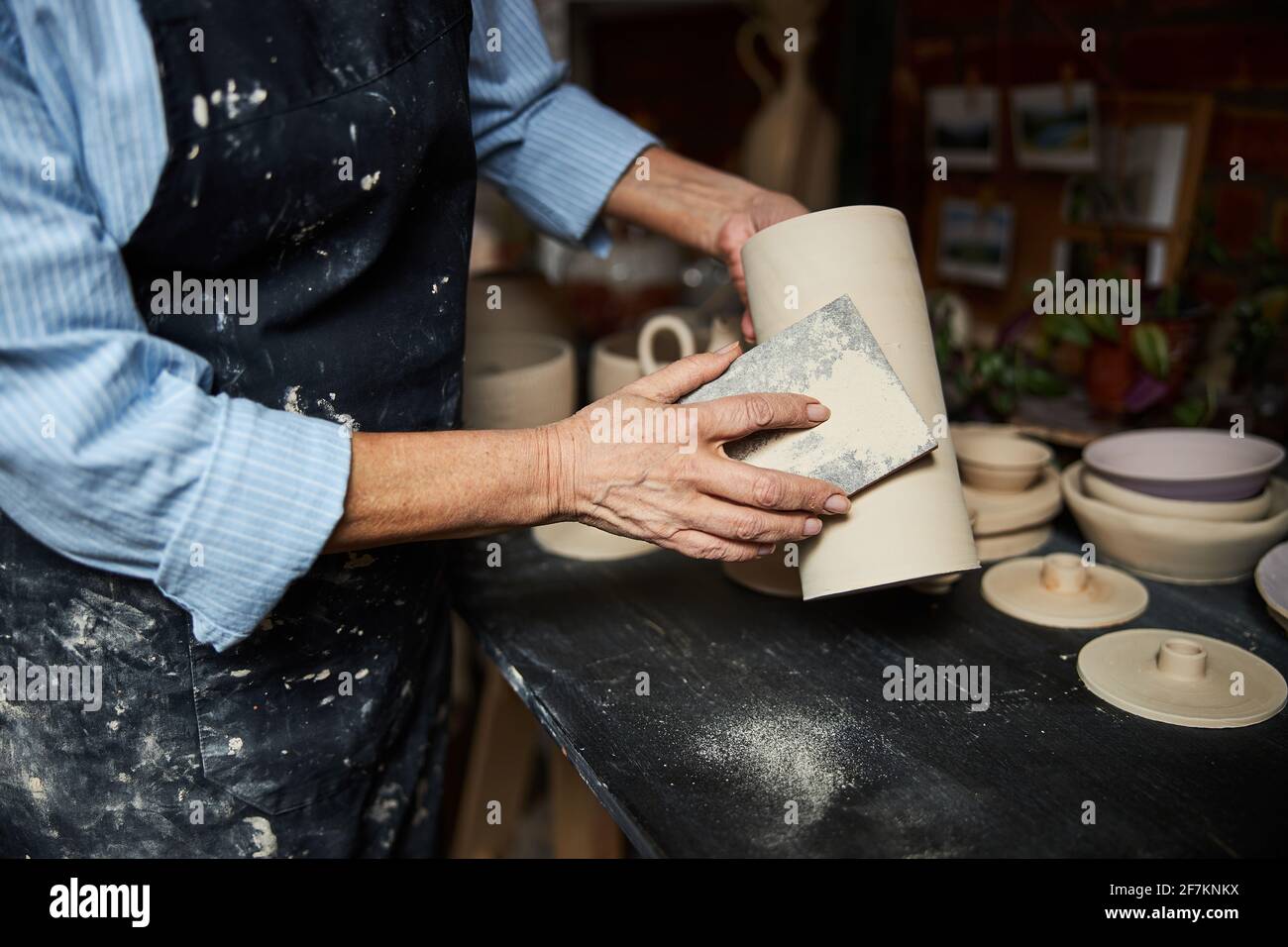Female ceramic artist polishing pottery in workshop Stock Photo - Alamy