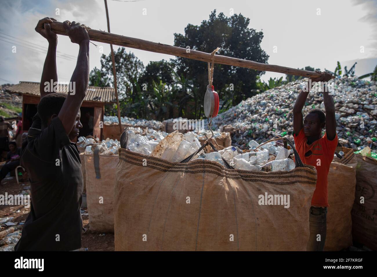KAMPALA, UGANDA Two workers carry a dump bag full of sorted plastic
