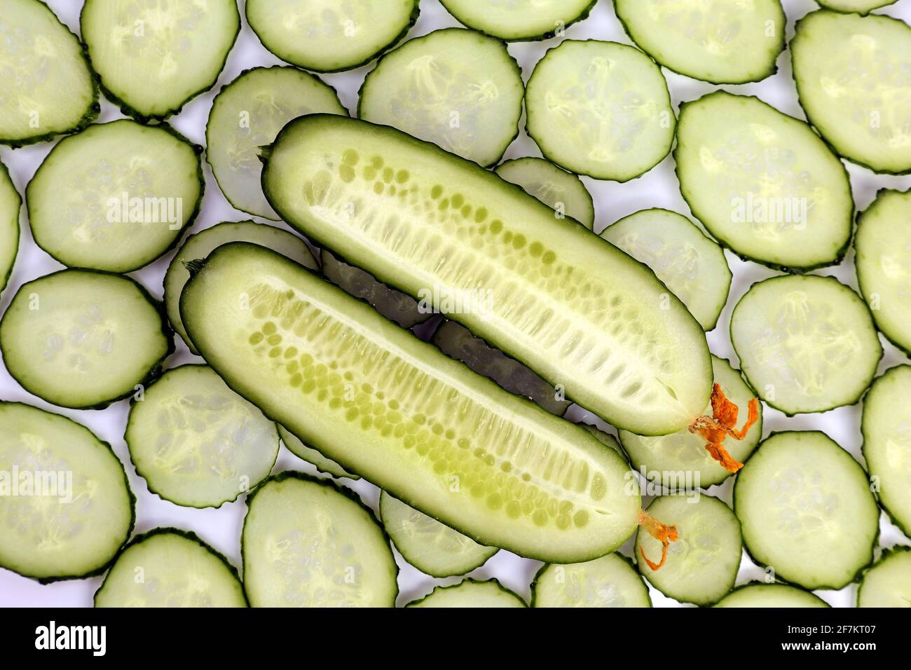 https://c8.alamy.com/comp/2F7KT07/cut-lengthwise-the-cucumber-on-the-background-of-sliced-cucumbers-crosswise-2F7KT07.jpg