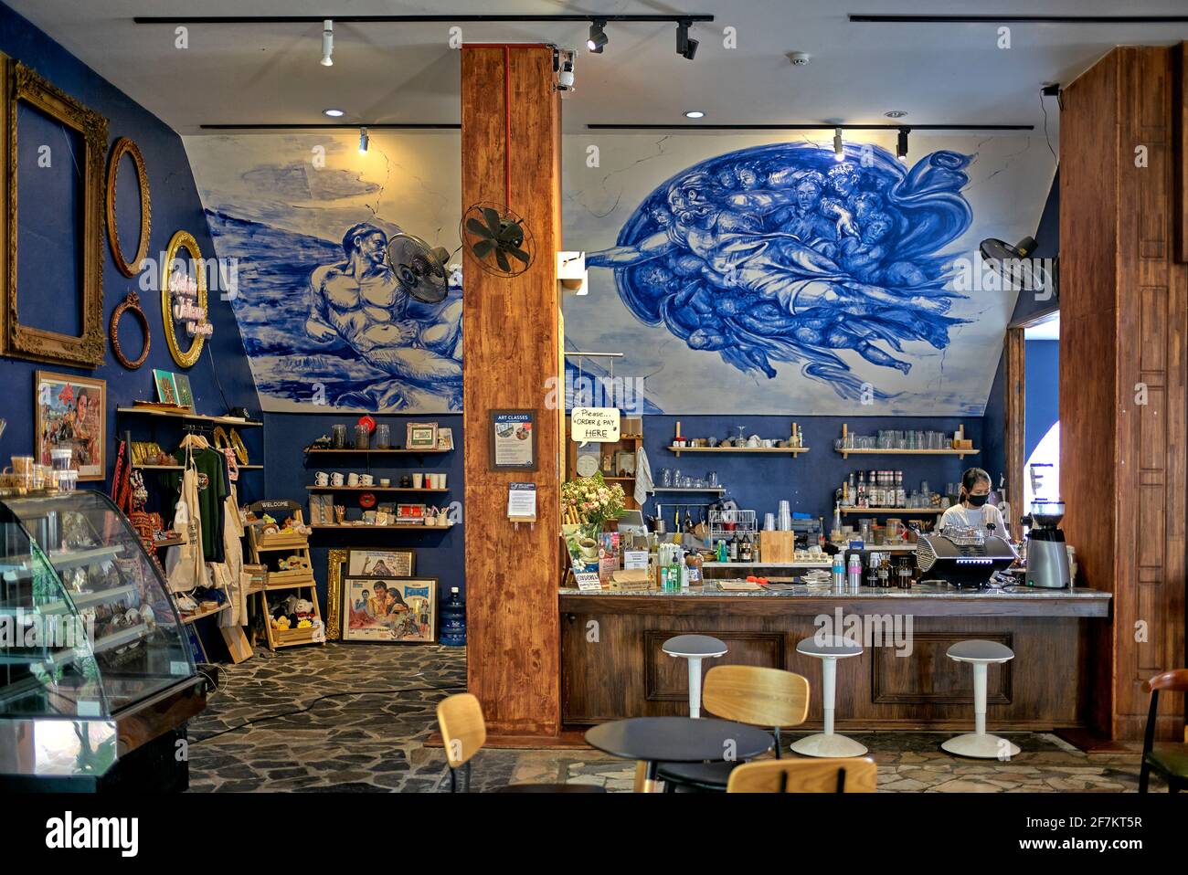 Art cafe interior with wall art of the 'Creation of Adam' masterpiece by Michelangelo Stock Photo