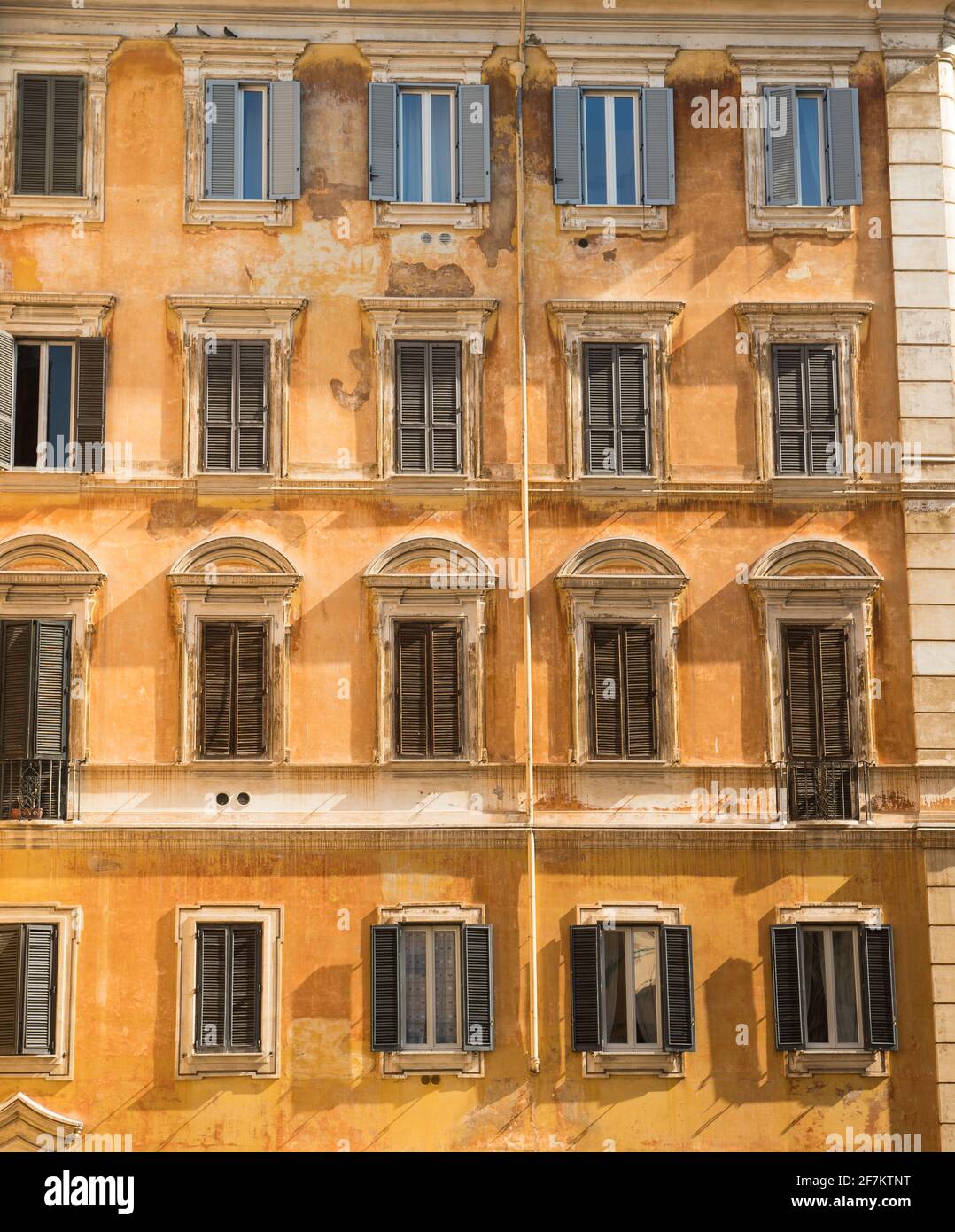 Typical old roman house facade with multiple windows ornaments. Stock Photo