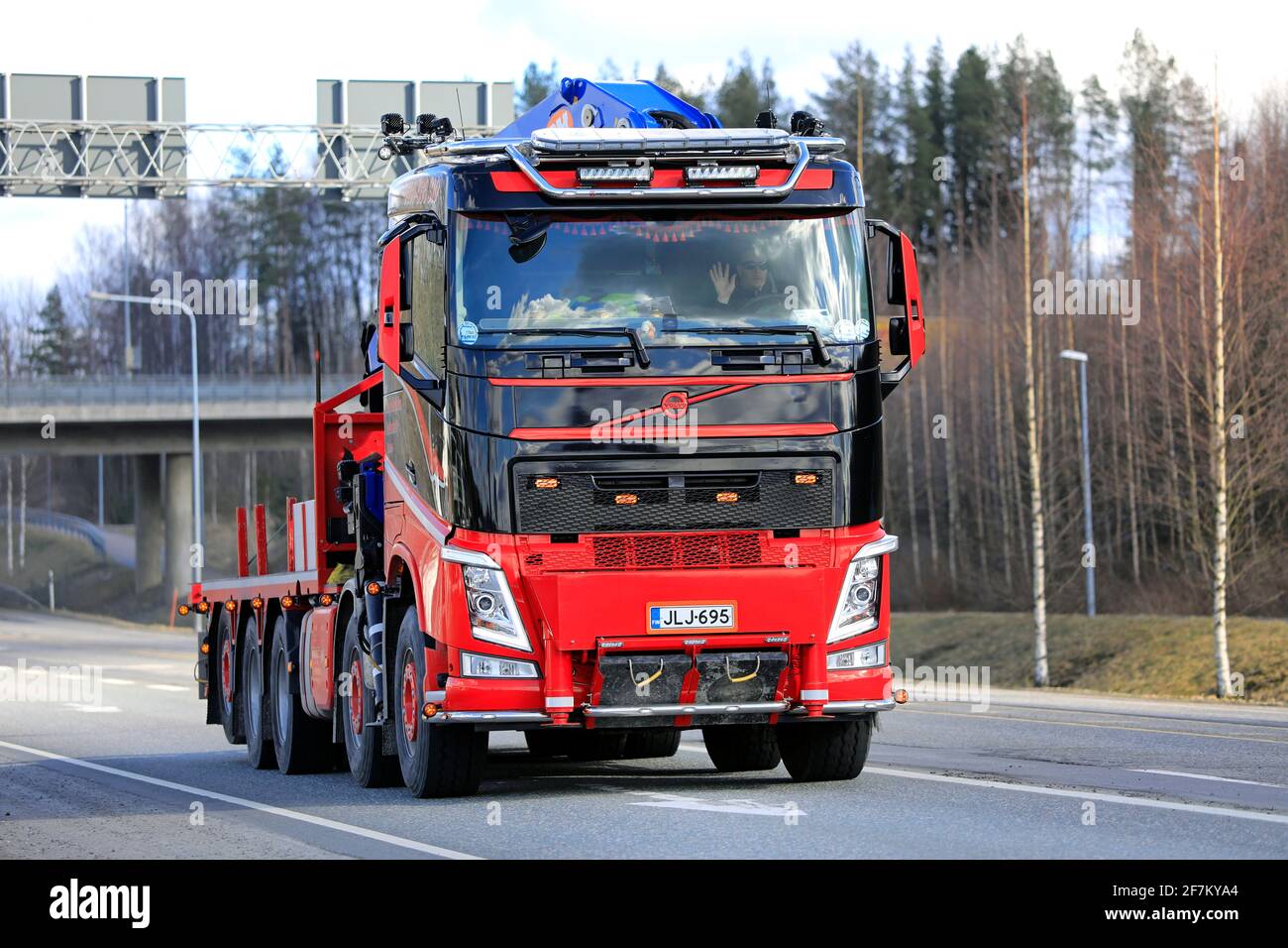 Red black Volvo mobile crane truck of Nosto ja Kuljetus Karttunen Oy on road in the spring in Forssa, Finland. April 1, 2021. Stock Photo